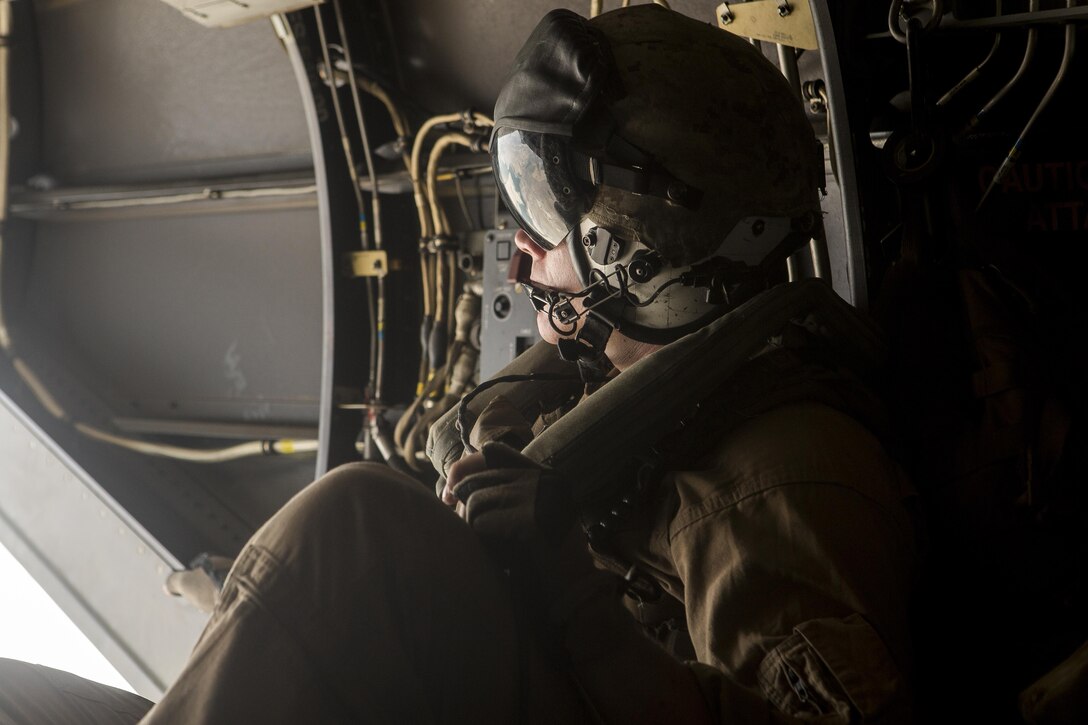 Corporal Tyler Jameson, a crew chief with Special-Purpose Marine Air-Ground Task Force Crisis Response-Africa, looks out the back of an MV-22B Osprey while traveling from Morón Air Base to Naval Station Rota, Spain, during a tactical recovery of aircraft and personnel exercise, August 3. The Marines flew approximately 60 miles from Morón Air Base to NS Rota to accomplish the TRAP mission. (U.S. Marine Corps photo by Staff Sgt. Vitaliy Rusavskiy/Released)