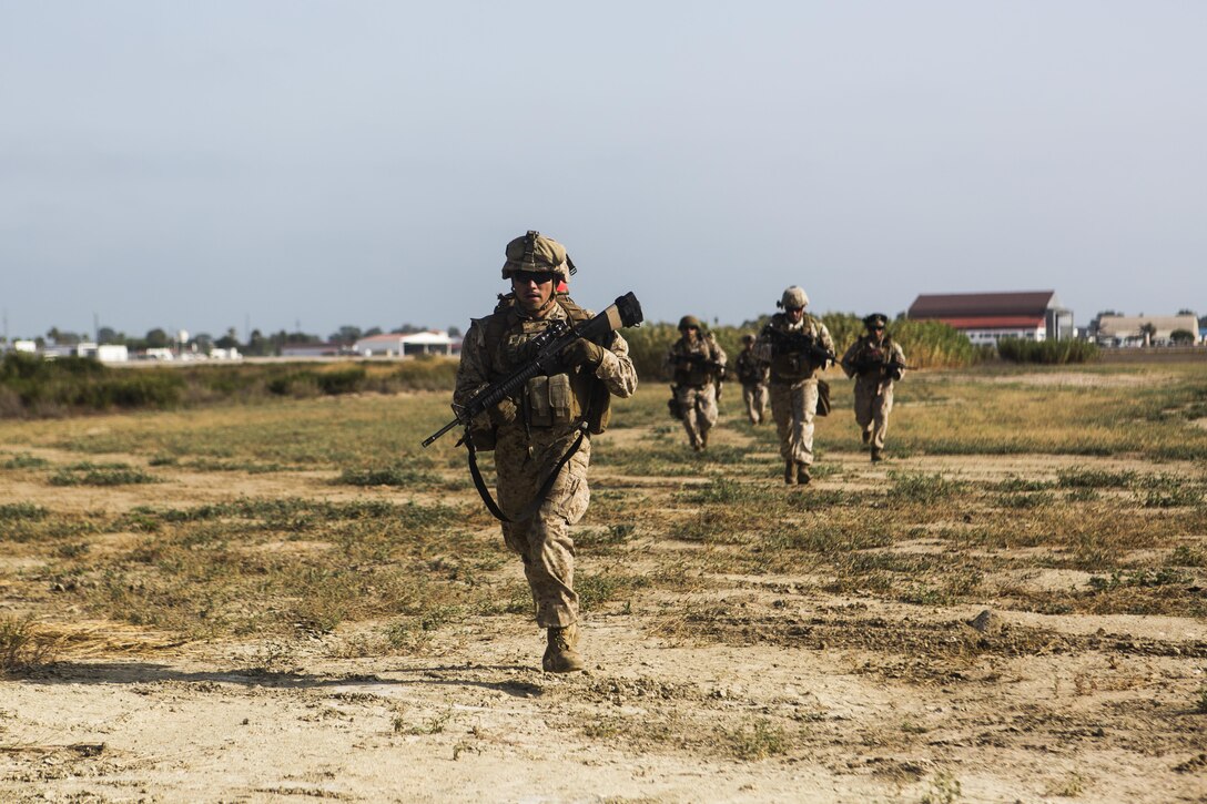 Marines with Special-Purpose Marine Air-Ground Task Force Crisis Response-Africa cross a field to establish a security perimeter during a tactical recovery of aircraft and personnel exercise aboard Naval Station Rota, Spain, August 3. SPMAGTF-CR-AF is a crisis contingency force ensuring the safety of Americans and American interests from any threats through prepared response forces, providing military assistance, when directed, in response to human and natural crises. (U.S. Marine Corps photo by Staff Sgt. Vitaliy Rusavskiy/Released)
