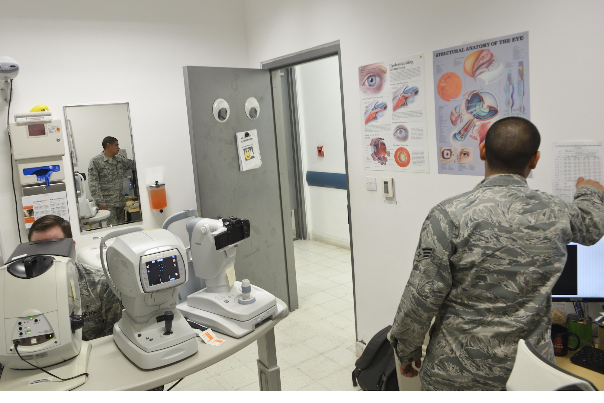 Senior Airman Adlai Ceja, 379th Expeditionary Medical Group optometry clinic, follows an answer sheet as patients speak the letters and numbers seen during an eye exam on a visual field analyzer August 7, 2015 at Al Udeid Air Base, Qatar. (U.S. Air Force photo/Staff Sgt. Alexandre Montes)