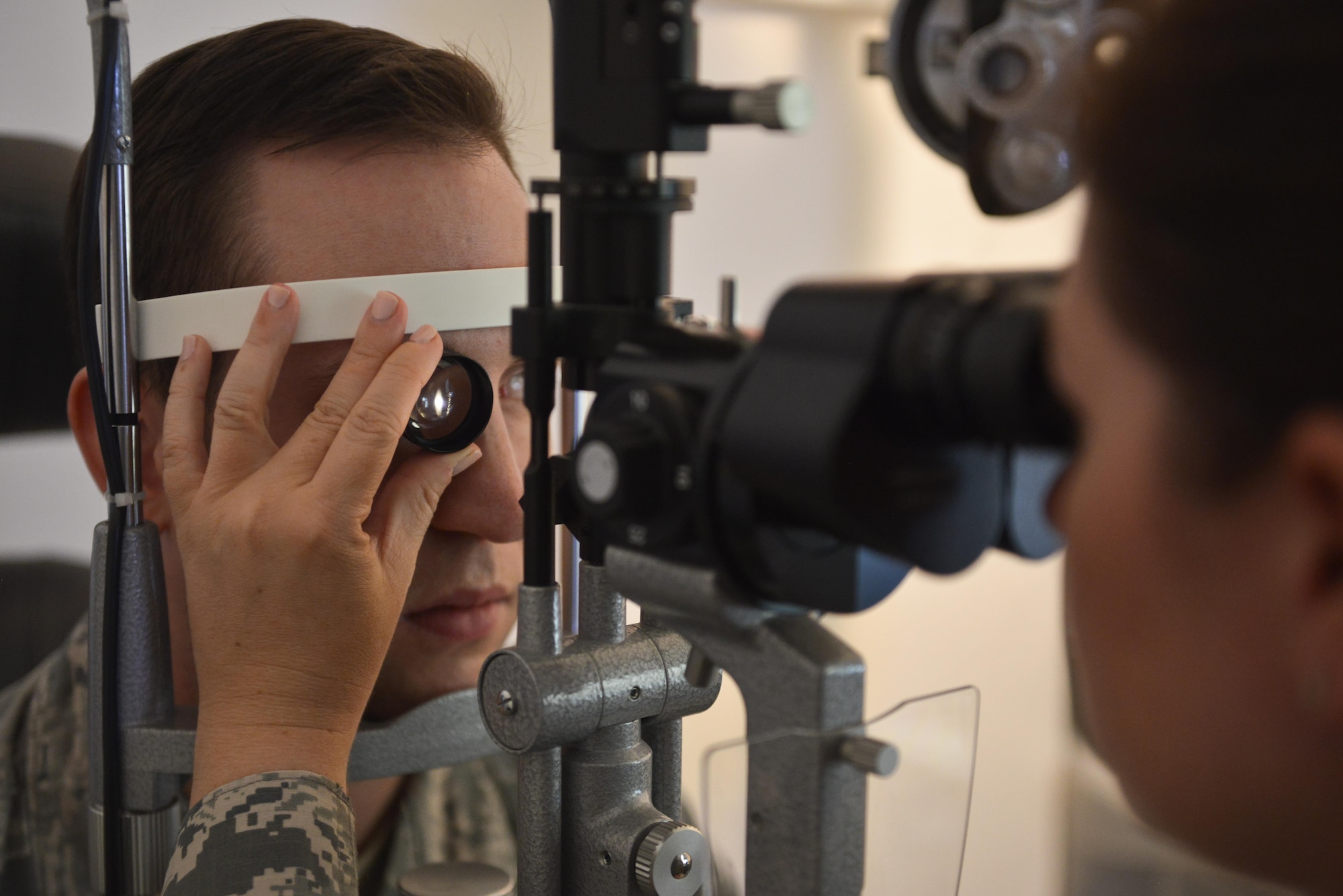 Capt. Lauren Matthews, 379th Expeditionary Medical Group optometry clinic, looks at a magnified 3-D view of a patient’s eye during a Slit-Lamp exam August 7, 2015 at Al Udeid Air Base, Qatar. (U.S. Air Force photo/Staff Sgt. Alexandre Montes)