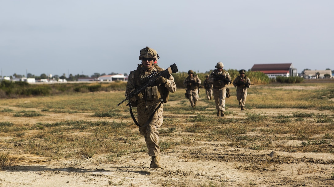 Marines with Special-Purpose Marine Air-Ground Task Force Crisis Response-Africa cross a field to establish a security perimeter during a tactical recovery of aircraft and personnel exercise aboard Naval Station Rota, Spain, August 3. SPMAGTF-CR-AF is a crisis contingency force ensuring the safety of Americans and American interests from any threats through prepared response forces, providing military assistance, when directed, in response to human and natural crises.