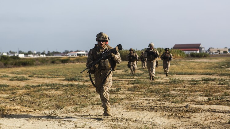 Marines with Special-Purpose Marine Air-Ground Task Force Crisis Response-Africa cross a field to establish a security perimeter during a tactical recovery of aircraft and personnel exercise aboard Naval Station Rota, Spain, August 3. SPMAGTF-CR-AF is a crisis contingency force ensuring the safety of Americans and American interests from any threats through prepared response forces, providing military assistance, when directed, in response to human and natural crises.