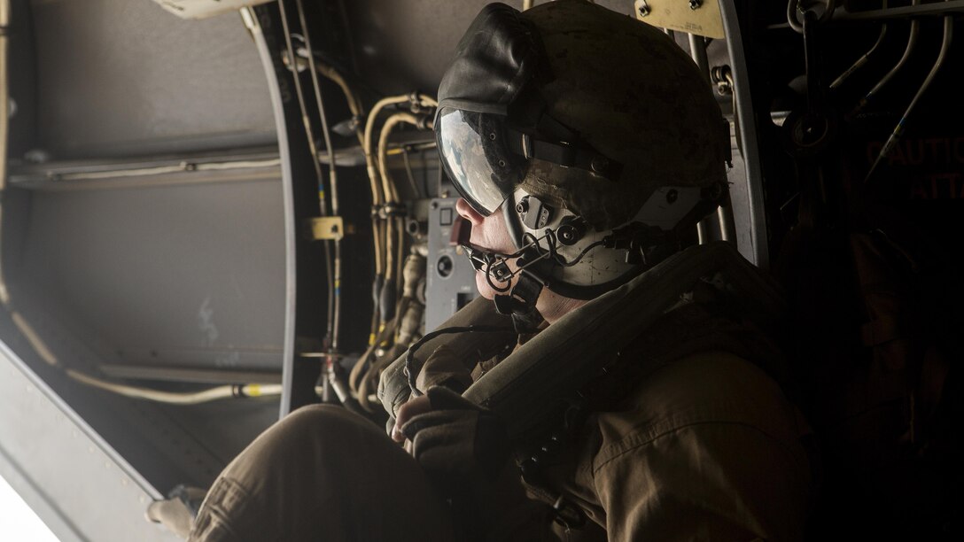 Corporal Tyler Jameson, a crew chief with Special-Purpose Marine Air-Ground Task Force Crisis Response-Africa, looks out the back of an MV-22B Osprey while traveling from Morón Air Base to Naval Station Rota, Spain, during a tactical recovery of aircraft and personnel exercise, August 3. The Marines flew approximately 60 miles from Morón Air Base to NS Rota to accomplish the TRAP mission.