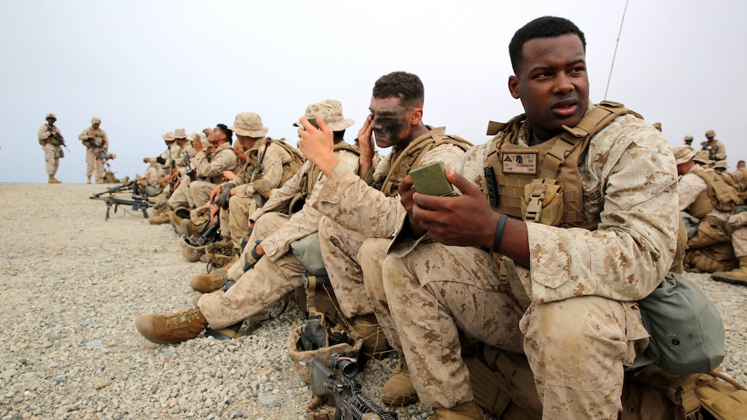 Marines with 3rd Battalion, 5th Marine Regiment, 1st Marine Division, apply camouflage paint before conducting a helicopter raid, as part of the Marine Corps Combat Readiness Evaluation (MCCRE), aboard Marine Corps Base Camp Pendleton, California, Aug. 4, 2015. The MCCRE is used evaluate the operational readiness of a designated unit. 