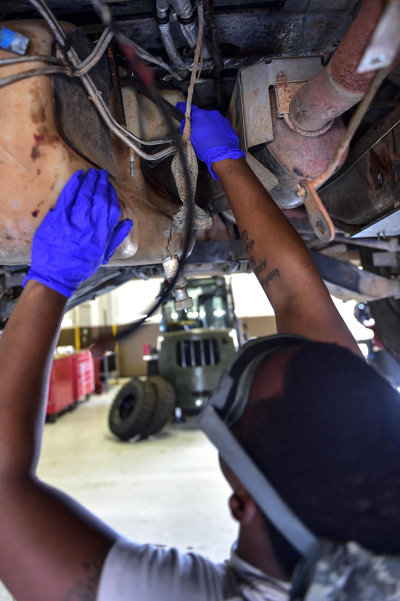 Senior Airman Elijah Sabree, 1st Special Operations Logistics Readiness Squadron vehicle mechanic apprentice, removes the fuel tank before replacing the transmission in a Humvee on Hurlburt Field, Fla., Aug 3, 2015. Training and flightline vehicles needing maintenance are serviced routinely by the vehicle maintenance flight to ensure mission success. (U.S. Air Force photo/Senior Airman Jeff Parkinson)