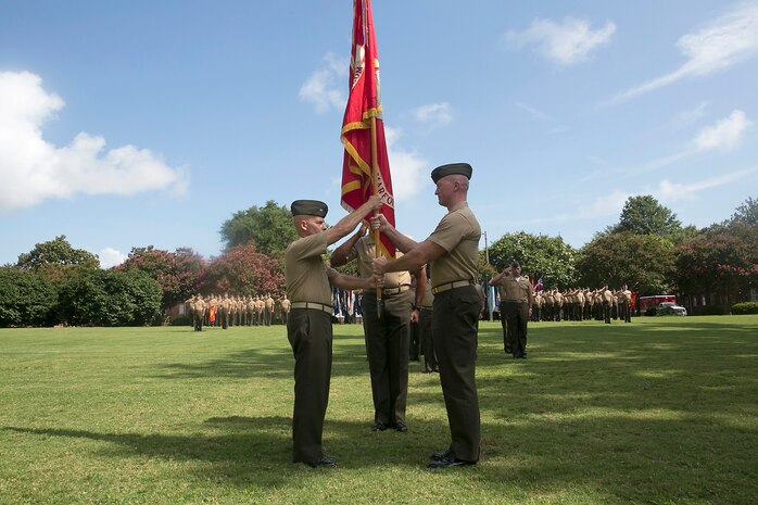 Col. Paul Ryan (right), commanding officer of Headquarters and Service Battalion, U. S. Marine Forces Command, passes the battalion colors to Col. Charles Dunne during a change-of-command ceremony aboard Naval Support Activity Hampton Roads, July 17, 2015. Col. Dunne takes command of the battalion after leaving 2nd Marine Aircraft Wing.