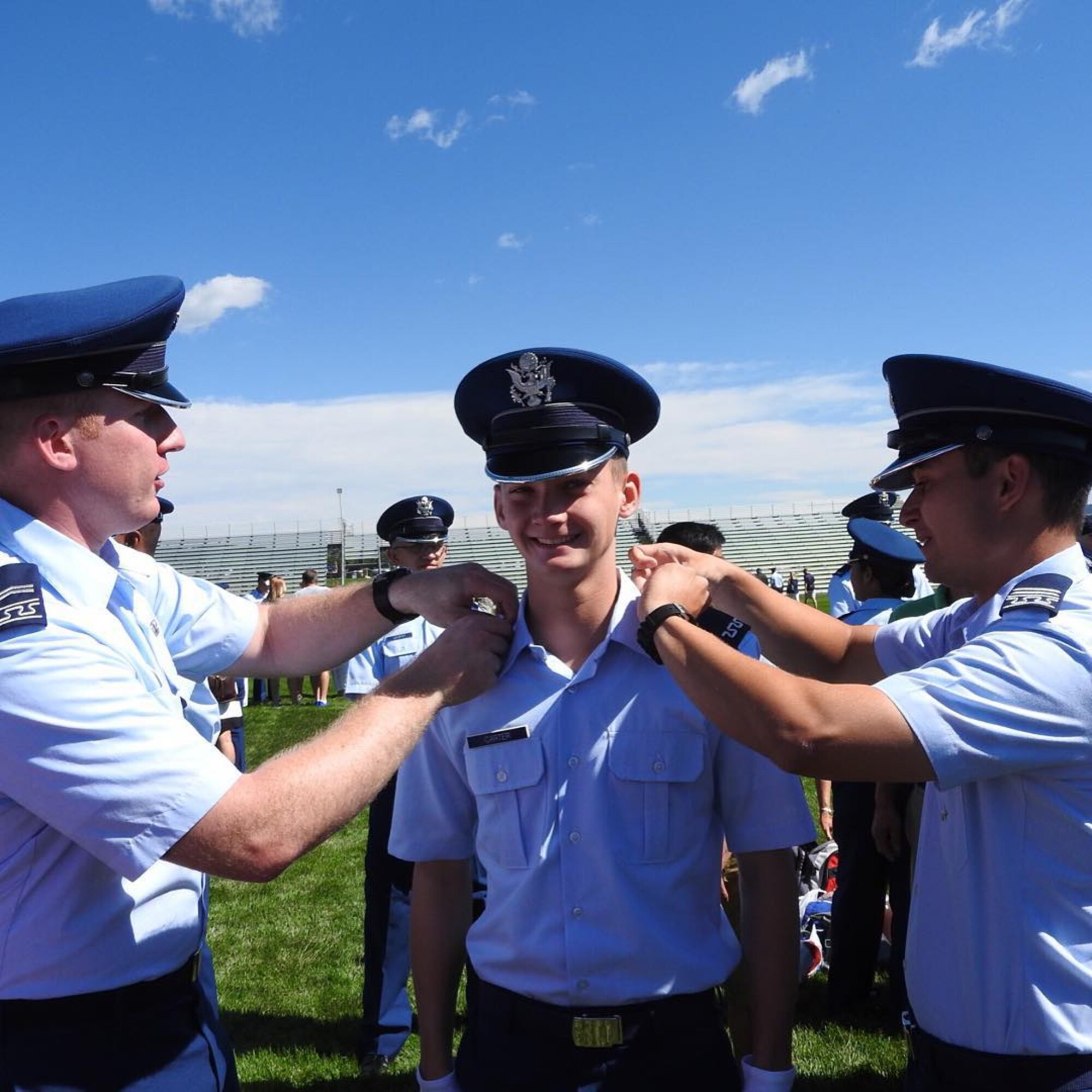 Freshly minted Cadet Fourth Class Matthew Carter, center, receives his shoulder boards during a ceremony, Aug. 4, 2015, at the U.S. Air Force Academy, Colorado Springs, Colorado. Carter now attends USAFA two years after finishing the on-site Teen Aviation Camp for youth exploring the academy as an option for college and a path to a military commission. "Before coming to the Academy, I had been pretty much convinced that I should go to a regular university and do ROTC," said Carter. "After my visit to the Academy, I did not have any doubts. When I left, I planned to return in two years." (Submitted photo/RELEASED)