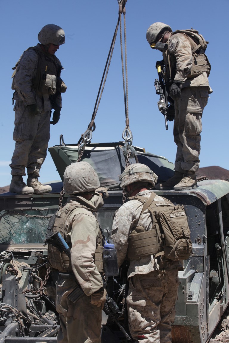 Marines with 1st Transportation Support Battalion, Combat Logistics Regiment 1, inspect chains used to lift a downed Humvee before pulling it onto a flatbed vehicle for extraction during a vehicle recovery mission as part of Integrated Training Exercise aboard Marine Corps Air Ground Combat Center Twentynine Palms, Calif., Aug. 4, 2015. The exercise allowed the Marines to train in a live fire environment and hone their tactical training procedures.