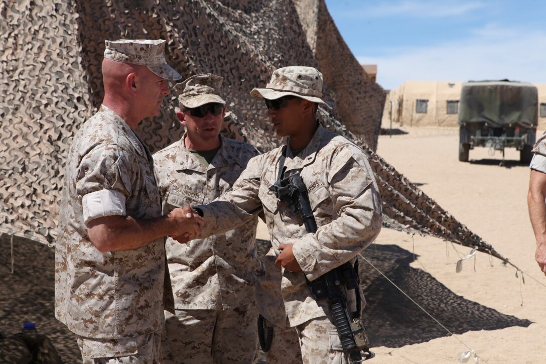 Brigadier Gen. David Ottignon, the commanding general of 1st Marine Logistics Group, shakes hands with 1st Lt. Gary Raymundo, a convoy commander with 1st Transportation Support Battalion, Combat Logistics Regiment 1, while visiting his Marines during Integrated Training Exercise at Forward Operating Base 3 aboard Marine Corps Ground Air Combat Center Twentynine Palms, Calif., Aug. 5, 2015. Ottignon toured the FOB and spoke with his Marines about morale, training and readiness.