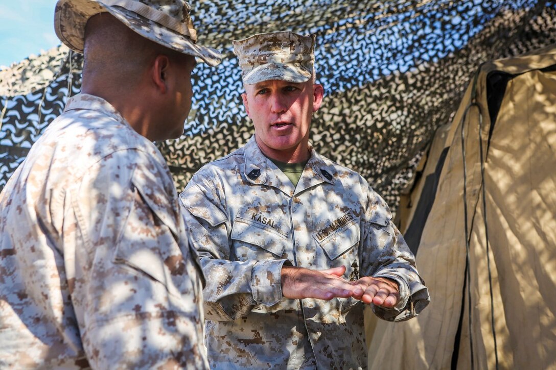 Sergeant Maj. Bradley Kasal, right, the sergeant major of I Marine Expeditionary Force, and Sgt. Maj. Michael E. Cedeno, sergeant major of 1st Battalion, 7th Marine Regiment, speak about training events taking place during an Integrated Training Exercise aboard Marine Air Ground Combat Center Twentynine Palms, Calif., Aug. 6, 2015. Kasal visited the combat center along with Lt. Gen. David H. Berger, commanding general of I MEF. ITX is conducted to enhance the integration and warfighting capability from all elements of the Marine Air Ground Task Force. ITX currently hosts units training to support Special Purpose Marine Air Ground Task Force Crisis Response Central Command 16.1. (U.S. Marine Corps Photo by Sgt. Rick Hurtado / Released).