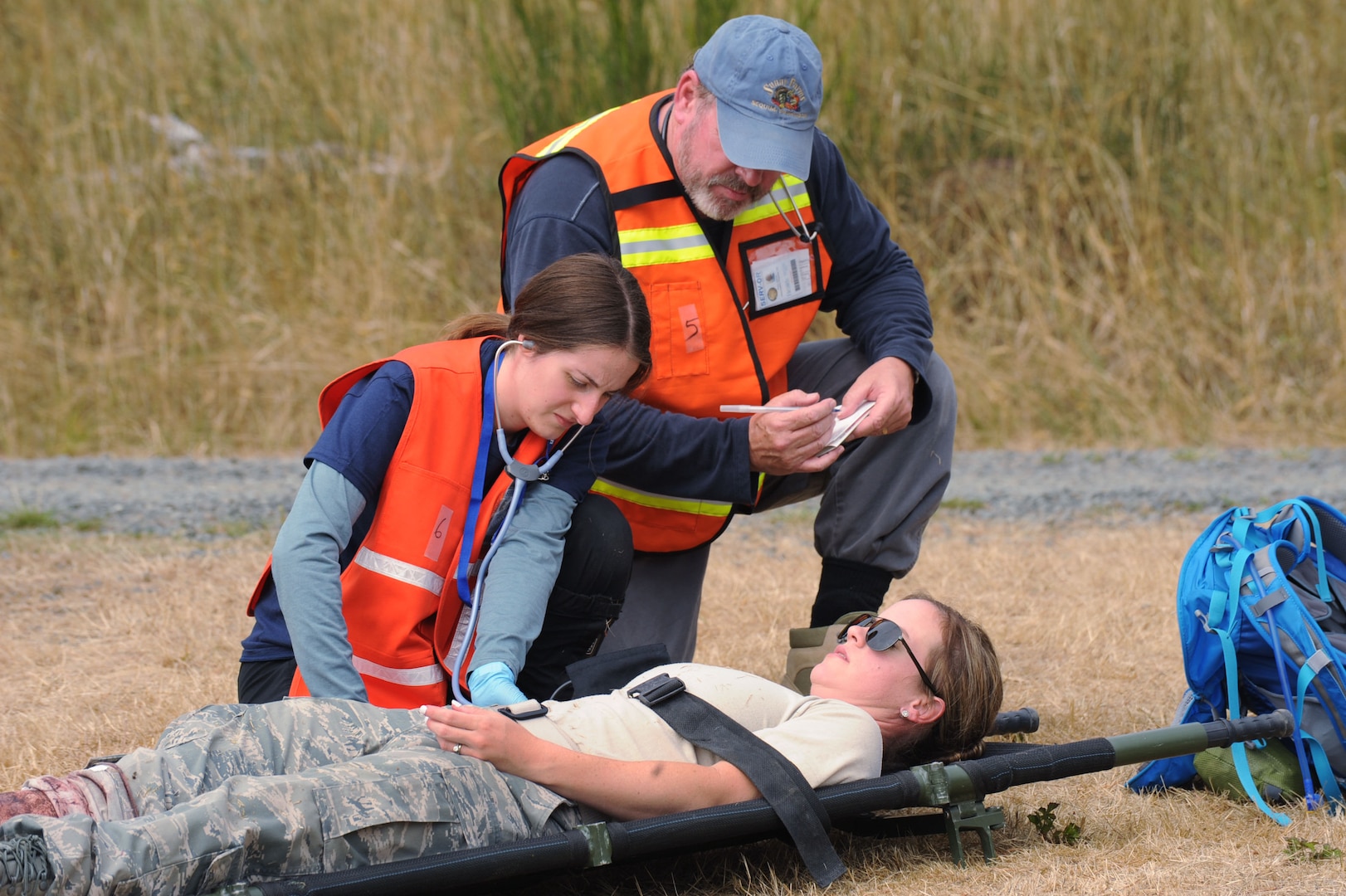First responders assist and prepare a victim for transport during Pathfinder-Minutemen Exercise, Aug. 5, 2015 at Camp Rilea in Warrenton, Oregon. The event is a joint multi-agency, multi-state disaster preparedness exercise based on response to a possible Cascadia Subduction Zone event. Officials believe the Northwest is overdue for a magnitude 7.0 or greater earthquake.