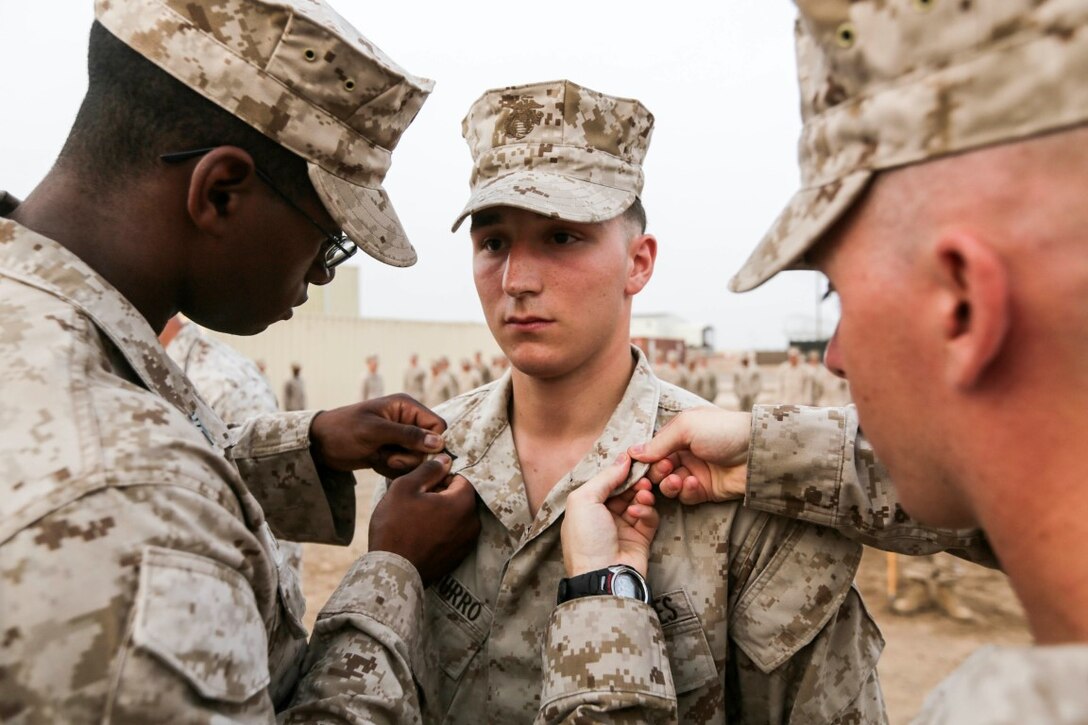 CAMP LEMONNIER, Djibouti (Aug. 2, 2015) U.S. Marine Cpl. Stephen Picciurro has his new rank insignia pinned on during a promotion ceremony.  Picciurro is a team leader with India Company, Battalion Landing Team 3rd Battalion, 1st Marine Regiment, 15th Marine Expeditionary Unit.  Elements of the 15th MEU are ashore in Djibouti for sustainment training to maintain and enhance the skills they developed during their pre-deployment training period.  The 15th MEU is currently deployed in support of maritime security operations and theater security cooperation efforts in the U.S. 5th Fleet area of operations. (U.S. Marine Corps photo by Sgt. Jamean Berry/Released)