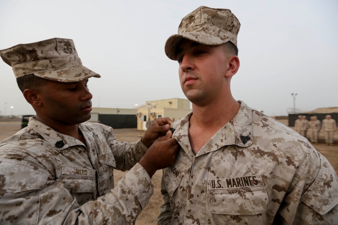 CAMP LEMONNIER, Djibouti (Aug. 2, 2015) U.S. Marine Staff Sgt. Shawn Reed, left, pins new rank onto Sgt. Ryan Jackson after Jackson was meritoriously promoted to the rank of corporal.  Jackson is a squad leader with Battalion Landing Team 3rd Battalion, 1st Marine Regiment, 15th Marine Expeditionary Unit.  Elements of the 15th MEU are ashore in Djibouti for sustainment training to maintain and enhance the skills they developed during their pre-deployment training period.  The 15th MEU is currently deployed in support of maritime security operations and theater security cooperation efforts in the U.S. 5th Fleet area of operations. (U.S. Marine Corps photo by Sgt. Jamean Berry/Released)