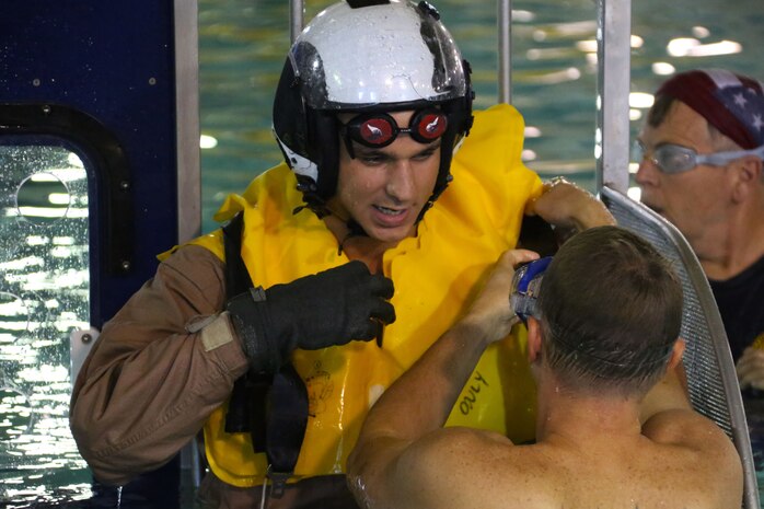 Cpl. Erban Maxwell, right, recieves guidance by Chieff Petty Officer Benjamin Sorensen during water survival training at Marine Corps Air Station Cherry Point, North Carolina, July 28, 2015. The Aviation Survival Training Center is the only water survival facility on any Marine Corps installation on the East Coast. Naval aviators are given classes on protocol and the gear they use in case of an emergency on an aircraft. The skills they learn in ASTC ensure 2nd Marine Aircraft Wing, its aviators and crew members are qualified and maintain the highest state of readiness. Maxwell is a maintanence administration specialist with Marine Transport Squadron 1 and Sorensen is an aviation survival equipment specialist with ASTC.