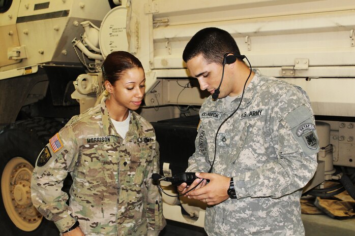 Spc. Tara Morrison (left) and Pfc. Brian Hollenbeck, both with Headquarters Support Company, U.S. Army Africa, test the SQ.410 Translation System in Vicenza, Italy.