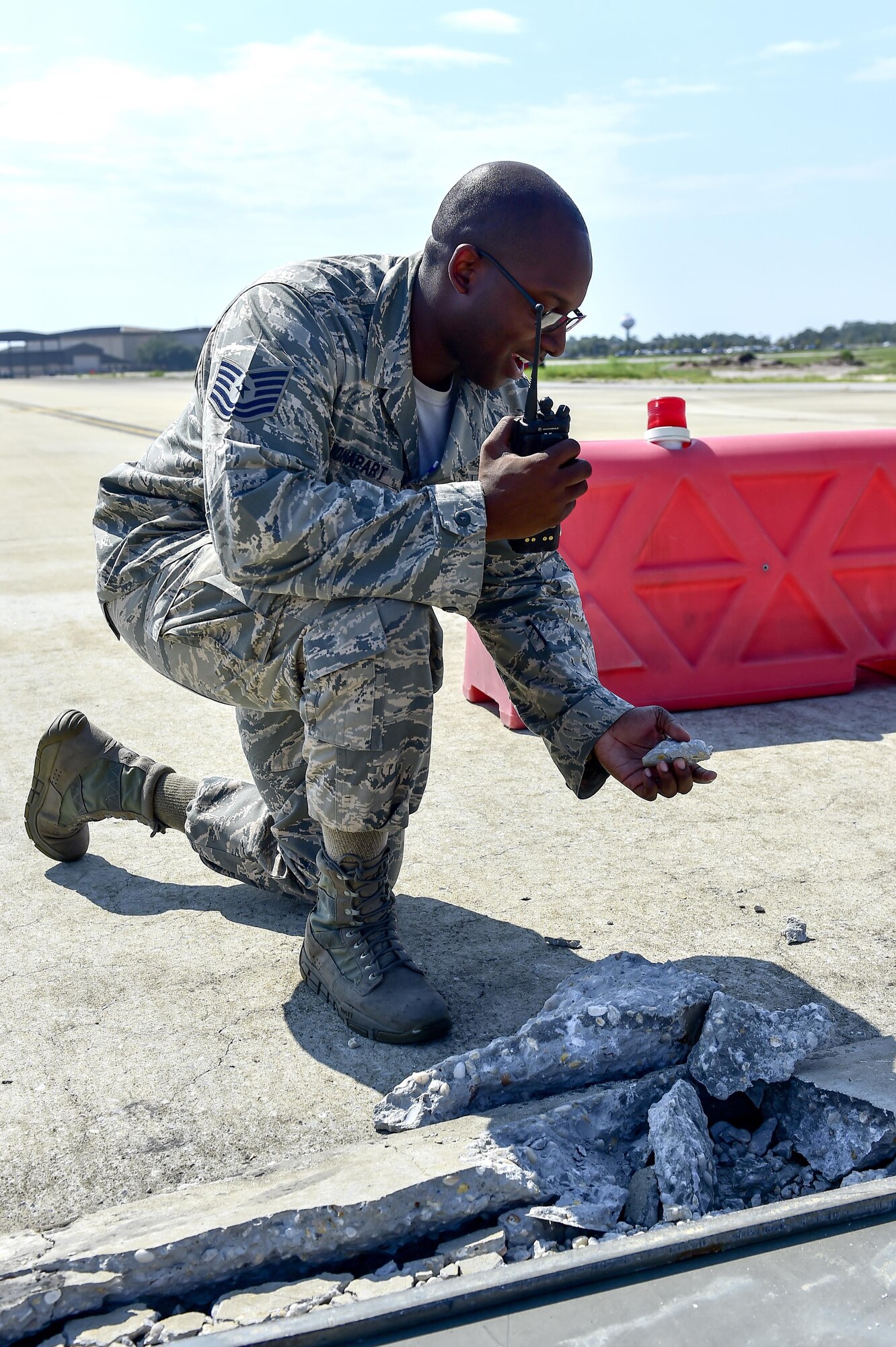 Tech. Sgt. Dominique Bonapart, 1st Special Operations Support Squadron airfield management operations NCO in-charge, calls in foreign object debris during an airfield check on Hurlburt Field, Fla., Aug. 4, 2015. Routine FOD checks are performed to prevent debris, such as rocks, from being sucked into the aircraft’s engine. (U.S. Air Force photo/Senior Airman Jeff Parkinson)