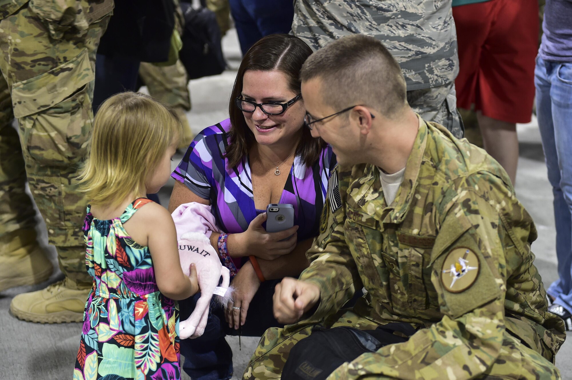 Staff Sgt. Jeremy Scott, 901st Special Operations Aircraft Maintenance Squadron instrument and flight control systems, gives a gift to his daughter during Operation Homecoming on Hurlburt Field, Fla., Aug. 7, 2015. Families and friends of 66 Airmen gathered at the Deployment Control Center to welcome home their loved ones from a recent deployment overseas. (U.S. Air Force photo/Senior Airman Jeff Parkinson)