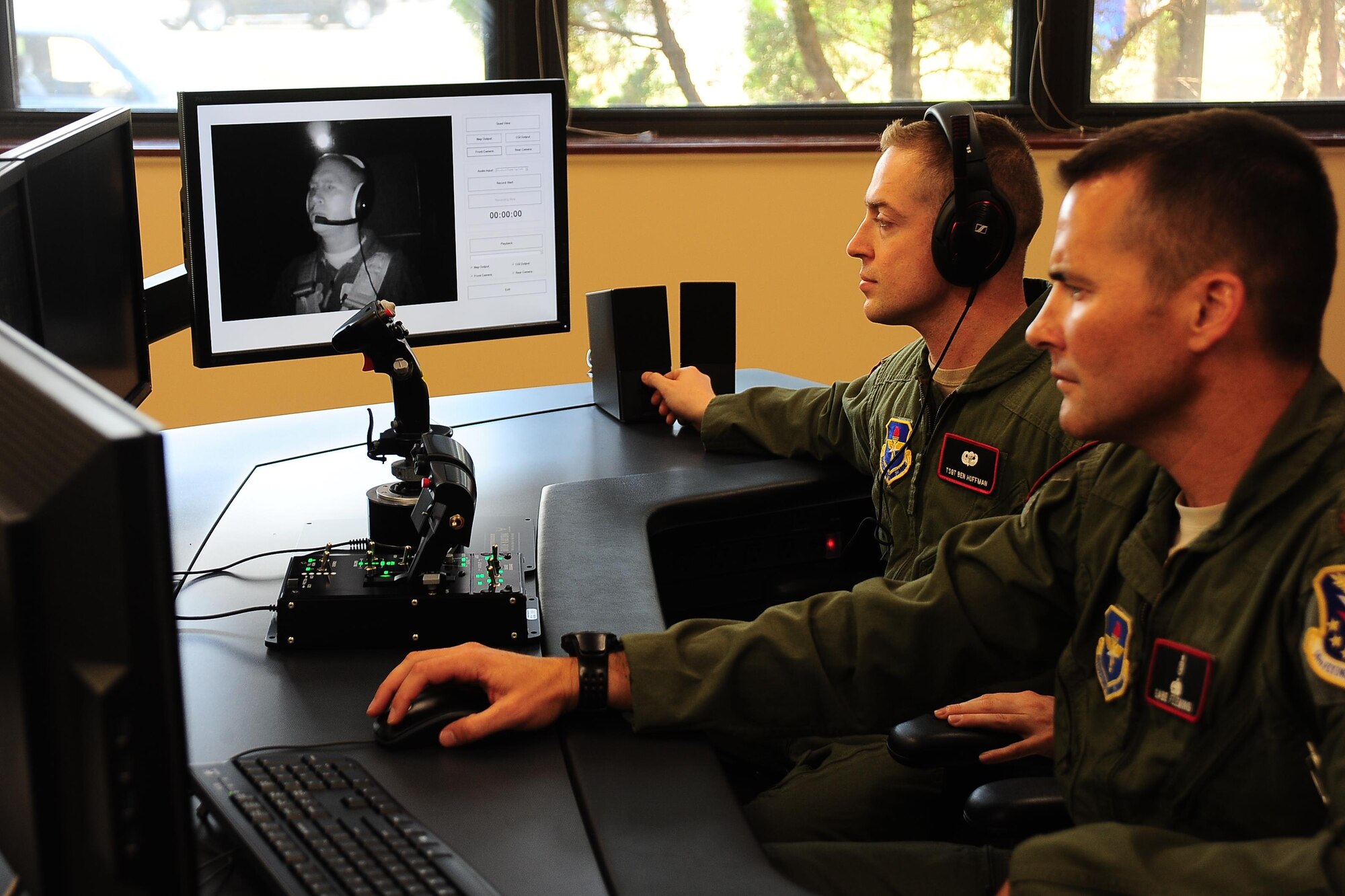 Tech. Sgt. Benjamin Hoffman and Maj. Michael Fleming monitor Col. James Fisher on the video feed from the cockpit of the new spatial disorientation simulator Aug. 5, 2015, at Columbus Air Force Base, Miss. Hoffman and Fleming directed Fisher through various sensations of roll, pitch and yaw to induce spatial disorientation. Hoffman is the 14th Medical Group Aerospace and Operational Physiology Flight chief, Fleming is the 14th MDG AOP Flight commander and Fisher is the14th Flying Training Wing vice commander. (U.S. Air Force photo/Airman 1st Class John Day)