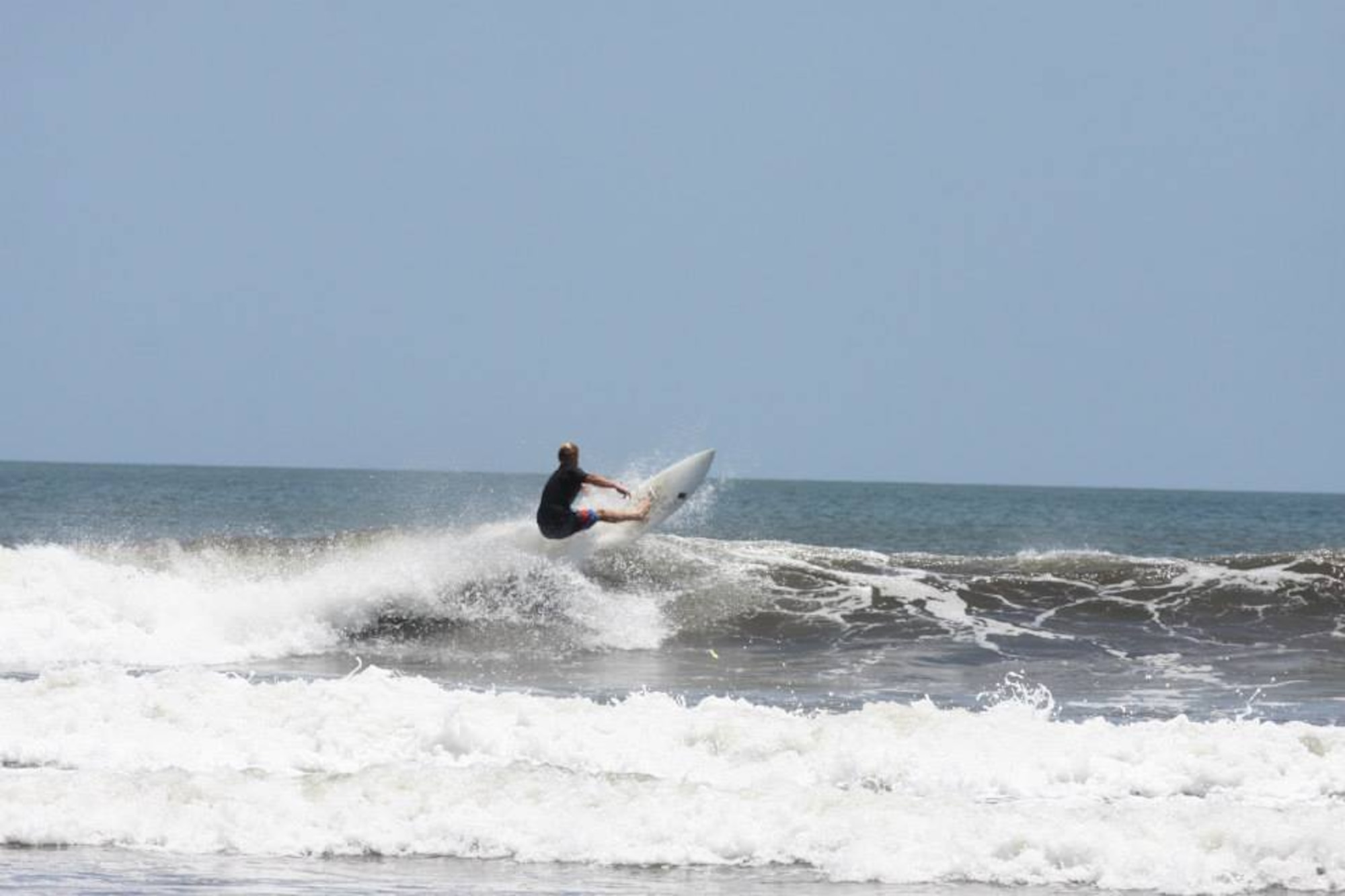 Senior Airman Joshua Calhoun, a 62nd Maintenance Squadron precision measurement equipment laboratory journeyman, surfs a wave Aug. 26, 2013, in Puerto Sandino, Nicaragua. Calhoun, an avid surfer, rescued a stranded surfer April 2015 at Ecola State Park, Oregon. He will be recognized as a hero by the American Red Cross Northwest Regions during the 2015 annual Heroes Luncheon later this year in Tacoma, Wash. (Courtesy photo)