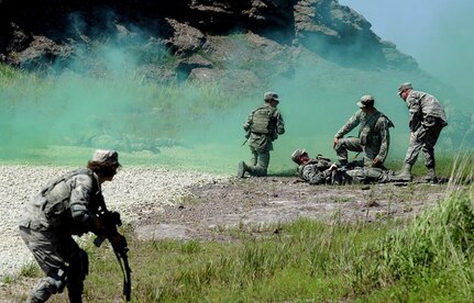 KUNSAN AIR BASE, Republic of Korea (Aug. 3, 2015) - Airmen from the 8th Security Forces Squadron provide care under fire during a tactical combat casualty care scenario, which was part of a three day combat readiness training. As Kunsan's first line of defense, security forces members must accurately and effectively perform their tactical capabilities to defend against threats. 