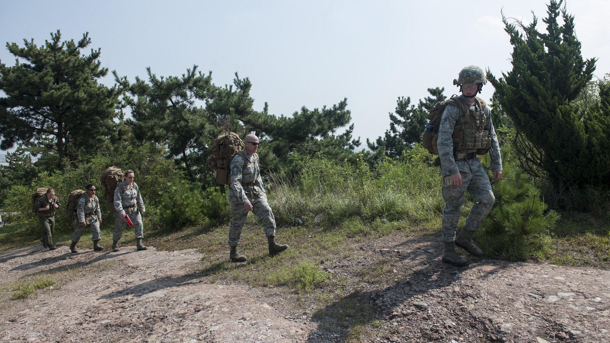 U.S. Air Force Staff Sgt. Matthew Edge (front), 8th Civil Engineer Squadron explosive ordnance disposal technician (right), searches the ground for an improvised explosive device as Chief Master Sgt. David “Falcon Chief” Abell, 8th Mission Support Group superintendent, and Lt. Col. Aimee “Falcon II” Alvstad, 8th MSG deputy commander, provide security during combat EOD training at Kunsan Air Base, Republic of Korea, Aug. 6, 2015. Alvstad and Abell witnessed the detection, identification, recovery and disposal of a simulated IED during a training operation conducted by U.S. Air Force explosive ordnance disposal technicians of the 8th CES as part of their hands-on immersion to the Wolf Pack. (U.S. Air Force photo by Senior Airman Katrina Heikkinen/Released)