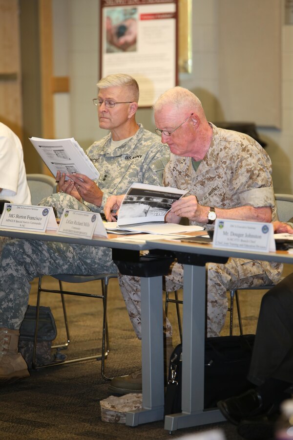 NEW ORLEANS –Maj. Gen. Burton Francisco, special assistant to the commander of North American Aerospace Defense Command, (left), and Lt. Gen. Richard P. Mills, commander of Marine Forces Reserve and Marine Forces North, follow along during a brief at the Defense Support of Civil Authorities seminar at the Federal City auditorium Aug. 5, 2015. The seminar focuses on events that are likely to happen in the area they occur. With the seminar taking place in Louisiana, the attention focused on hurricane response and coordination, using Hurricane Katrina as a reference. (U.S. Marine Corps Photo by Cpl. J. Gage Karwick/Released)