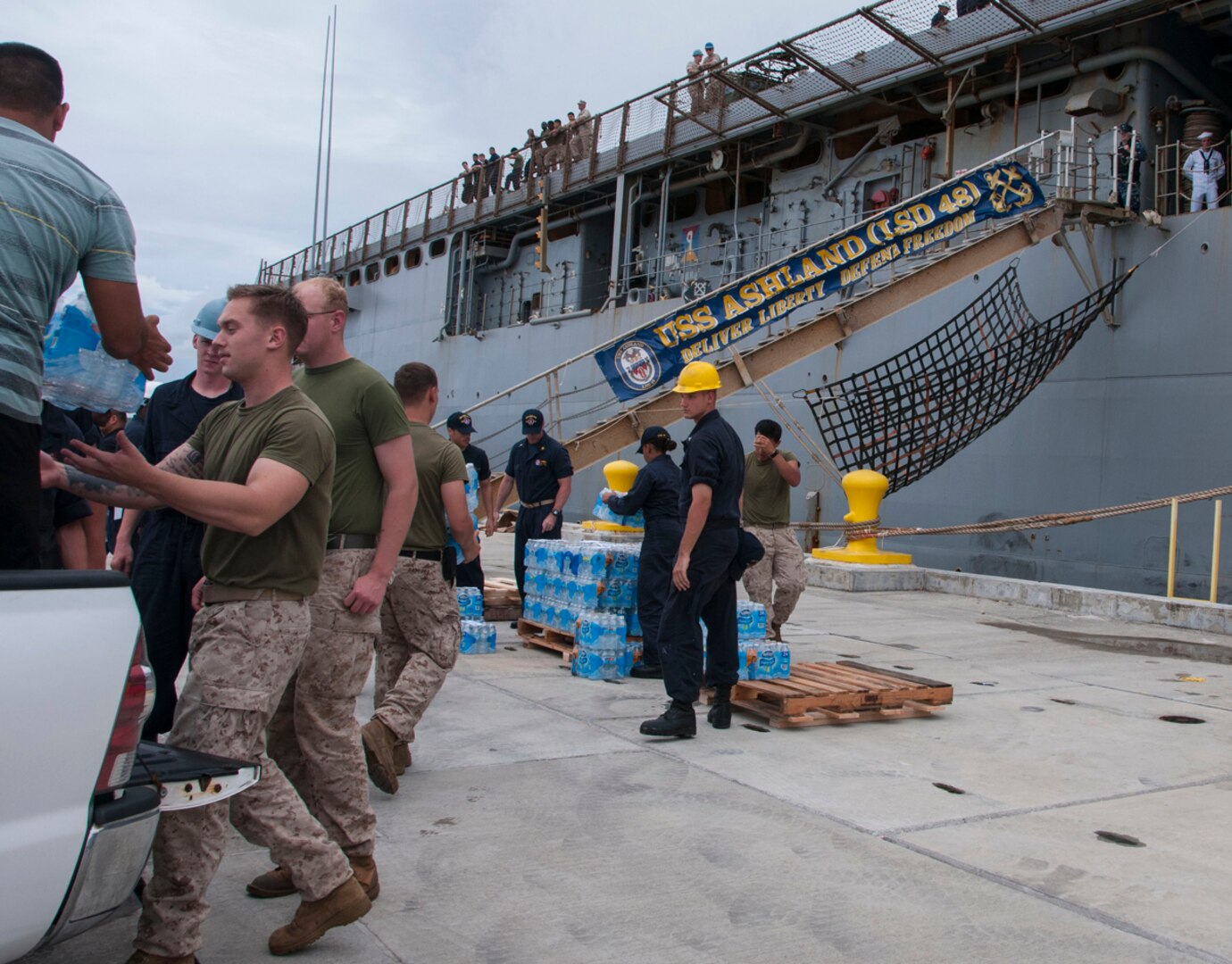 APRA HARBOR, Guam (Aug. 6, 2015) - Sailors and Marines load cases of water onto the amphibious dock landing ship USS Ashland (LSD 48) in preparation for the ship getting underway to deploy to Saipan. Ashland and embarked 31st Marine Expeditionary Unit (31st MEU) will provide relief in the aftermath of Typhoon Soudelor which devastated the island Aug. 2-3. 