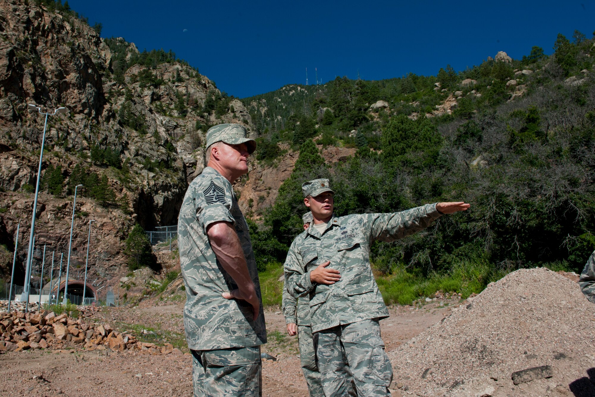 CHEYENNE MOUNTAIN AIR FORCE STATION, Colo. – Chief Master Sgt. of the Air Force James A. Cody learns about the mud slides of 2013 from Maj. Anthony Alecci, 721 Civil Engineer Squadron, during his visit to Cheyenne Mountain Air Force Station, Aug. 6, 2015. The rockslide left nearly 5,000 cubic yards of mud, rock and uprooted trees partially covering the entrance to the mountain. Cody was at CMAFS to get a tour of the facilities and visit with Airmen. (U.S. Air Force photo by Airman 1st Class Rose Gudex) 