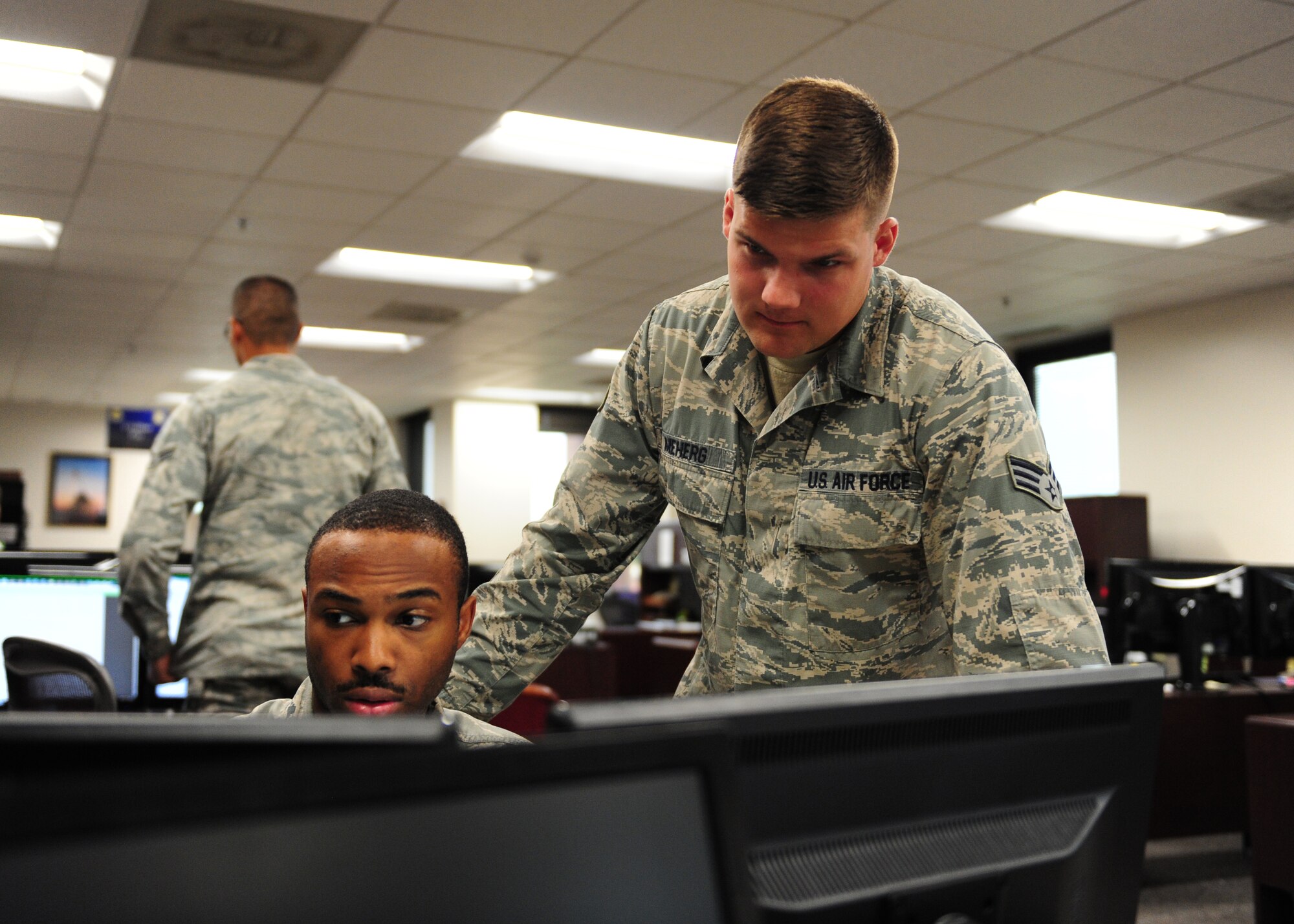 Senior Airman Mason Meherg, 509th Comptroller Squadron financial services technician, conducts training with a co-worker June 18, 2015 at Whiteman Air Force Base, Mo. Meherg was recently named one of 12 Outstanding Airmen of the Year for 2015. (U.S. Air Force photo by Senior Airman Joel Pfiester/Released)