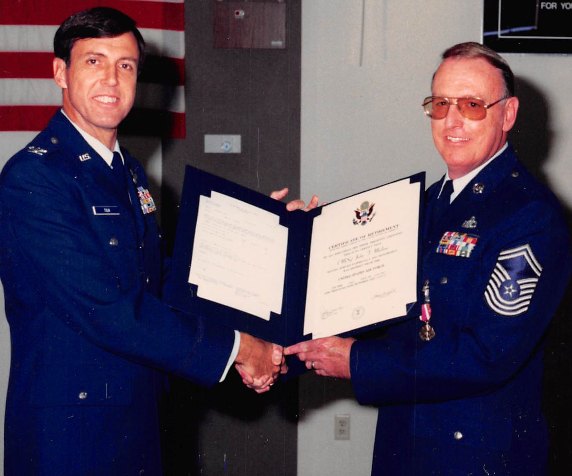 Chief Master Sgt. John Malone, right, retires after serving 26 years on active duty at a ceremony held on Nellis Air Force Base, Nev., in 1990. Malone served a combined 52 years on active duty and in civilian service. (Courtesy photo)