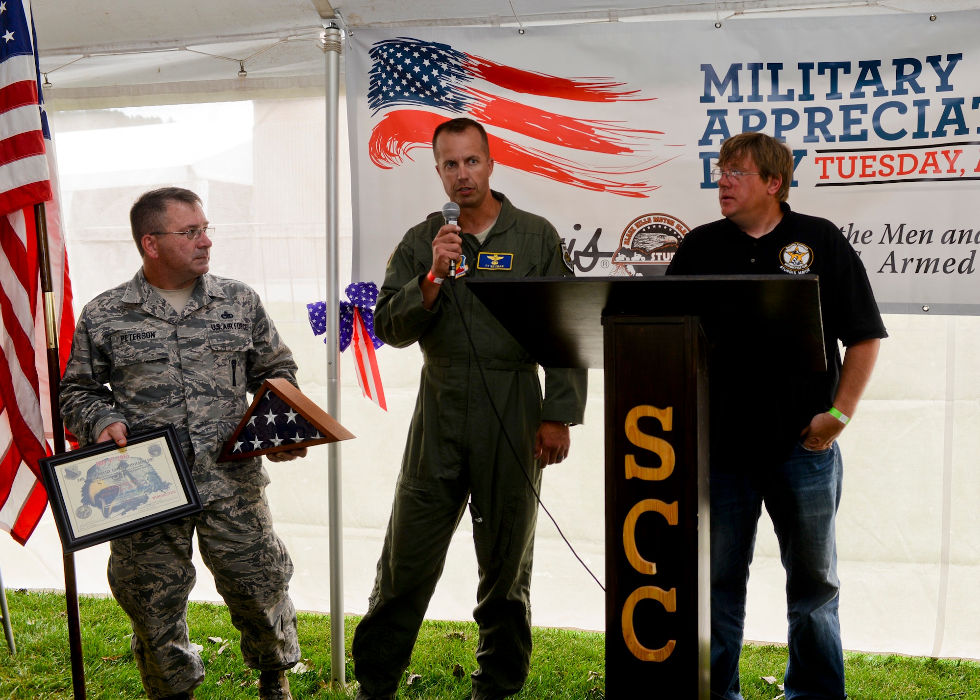 Col. Ty Neuman, 28th Bomb Wing vice commander, recognized and honored four veterans for their  service during a special ceremony in honor of military appreciation day at the 2015 Dakota Thunder Motorcycle Run at Sturgis, S.D., Aug. 4, 2015. Neuman presented the honorees with a U.S. flag that was flown in combat over Iraq and Syria in support of Operation Inherent Resolve. (U.S. Air Force photo by Senior Airman Anania Tekurio/Released)