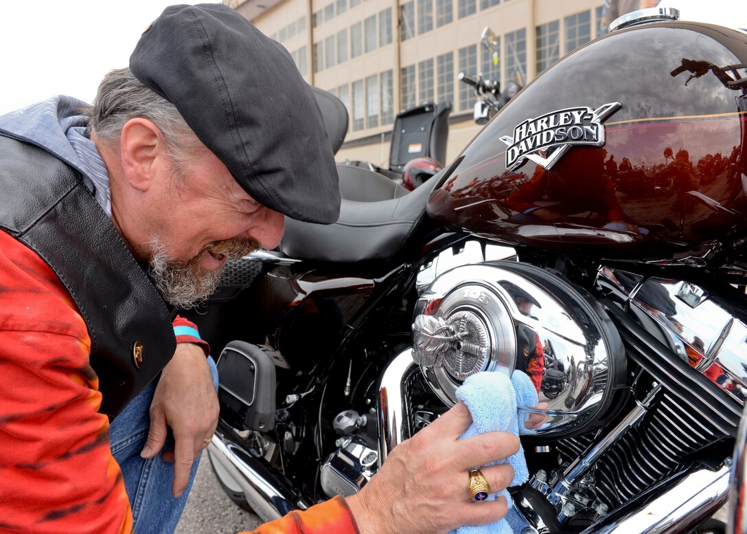 Kevin Goyer, Project Solutions Inc. program manager for Ellsworth, polishes the chrome on his motorcycle during the 2015 Dakota Thunder Motorcycle Run at Ellsworth Air Force Base, S.D., Aug. 4, 2015. Hosted by the Green Knights Dakota Thunder Motorcycle Club, Goyer was one of 200 participants to ride en masse to Sturgis, S.D., where a military appreciation ceremony recognized local veterans and honored military members past and present. (U.S. Air Force photo by Senior Airman Anania Tekurio/Released)