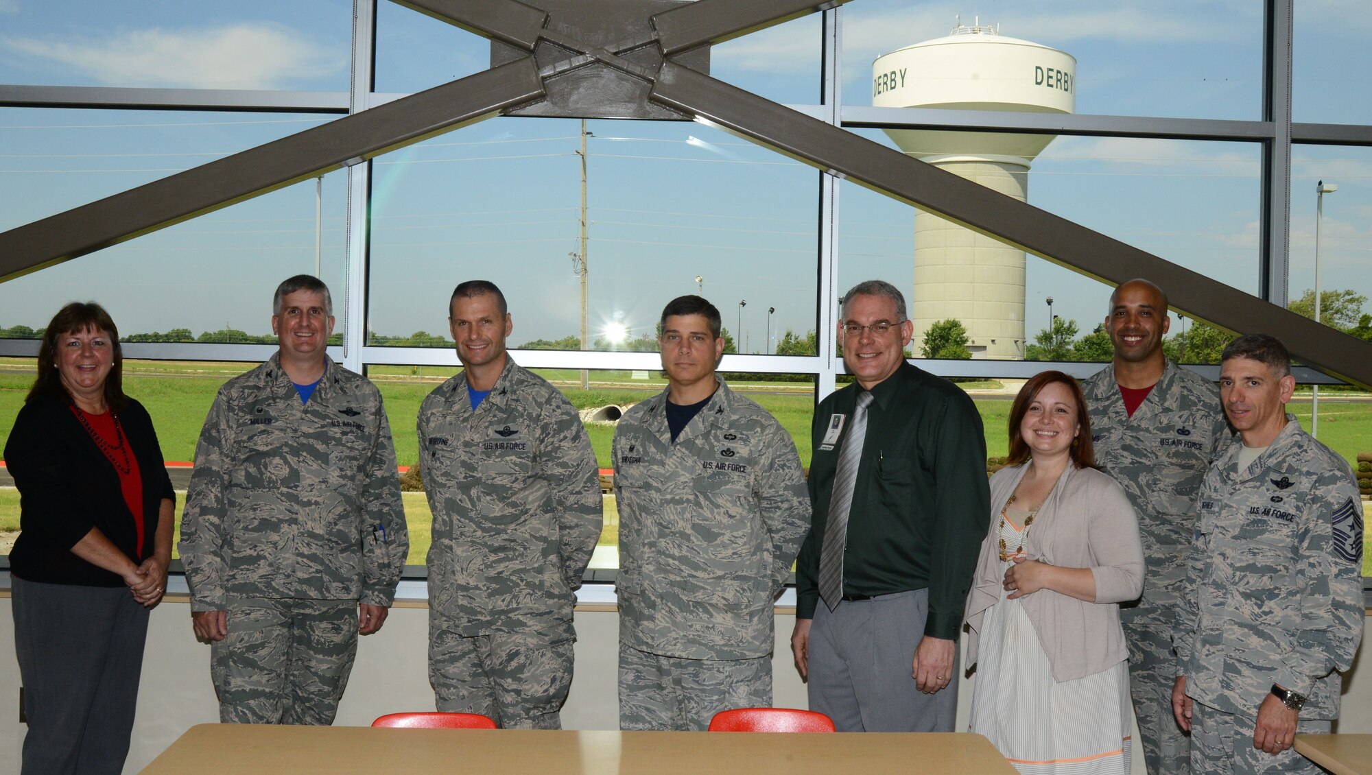 Leaders from McConnell and Derby North Middle School pose for a photo in a classroom, Aug. 7, 2015, at the school in Derby, Kan. DNMS invited McConnell’s leaders to a walking tour of the new facility to show how they assist with the development of children of the local community and of service members alike. (U.S. Air Force photo by Airman 1st Class Christopher Thornbury)