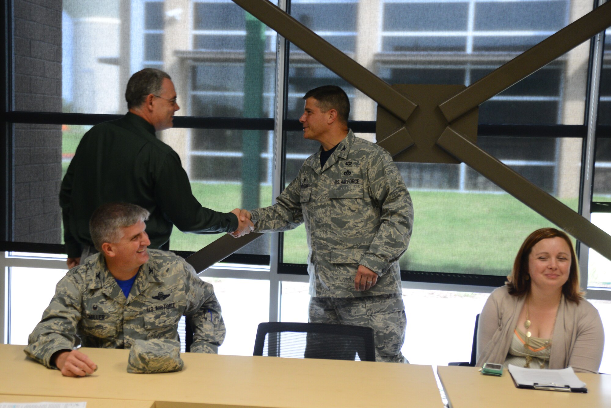 Jeff Smith, Derby North Middle School principal, presents a challenge coin to Col. Matthew Benivegna, 22nd Mission Support Group commander, Aug. 7, 2015, at the school in Derby, Kan. Smith wanted to show his appreciation for Team McConnell by using the military tradition of coining each of the service members on the tour. (U.S. Air Force photo by Airman 1st Class Christopher Thornbury)