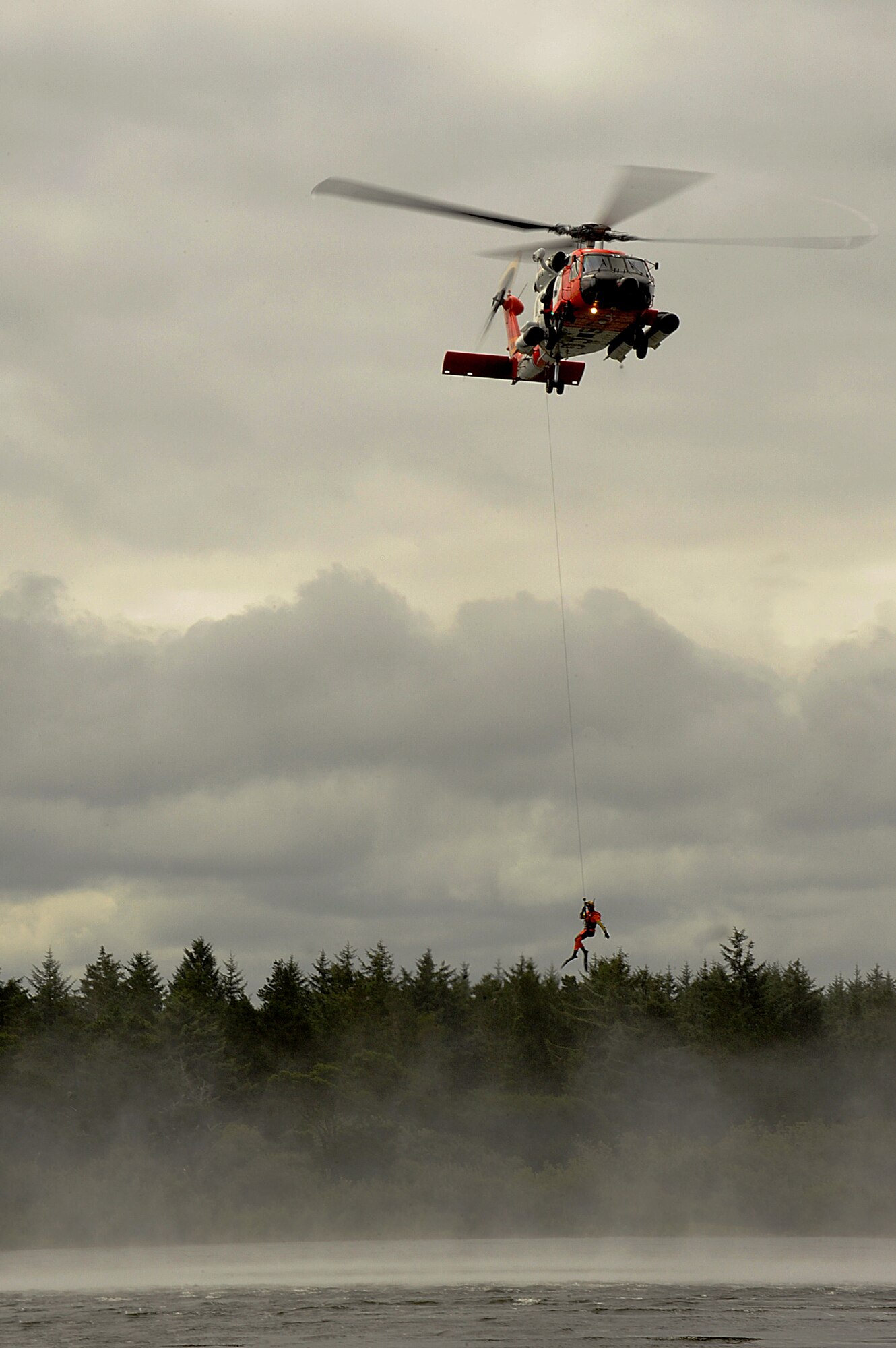 A U.S. Coast Guard HH-60 Jayhawk helicopter, from Air Station Astoria, drops a rescue diver into Slusher Lake at Camp Rilea, in Warrenton, Oregon, during the Pathfinder-Minutemen Exercise, Aug. 5, 2015 at Camp Rilea in Warrenton, Ore. The annual event is a joint multi-agency, multi-state disaster preparedness exercise based on response to a possible Cascadia Subduction Zone event. Officials believe the Northwest is overdue for a magnitude 7.0 or greater earthquake. (U.S. Air National Guard photo by Tech. Sgt. John Hughel, 142nd Fighter Wing Public Affairs/Released)
