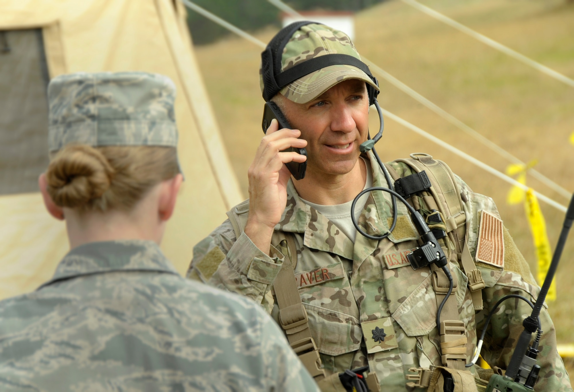 Lt. Col. John Graver, commander of the 304th Rescue Squadron in Portland, Ore., uses a cell phone and other communication equipment to help relay instructions to first responders and other participants taking part in the Pathfinder-Minutemen Exercise, Aug. 5, 2015 at Camp Rilea in Warrenton, Ore. The event is a joint multi-agency, multi-state disaster preparedness exercise based on response to a possible Cascadia Subduction Zone event. Officials believe the Northwest is overdue for a magnitude 7.0 or greater earthquake. (U.S. Air National Guard photo by Tech. Sgt. John Hughel, 142nd Fighter Wing Public Affairs/Released)