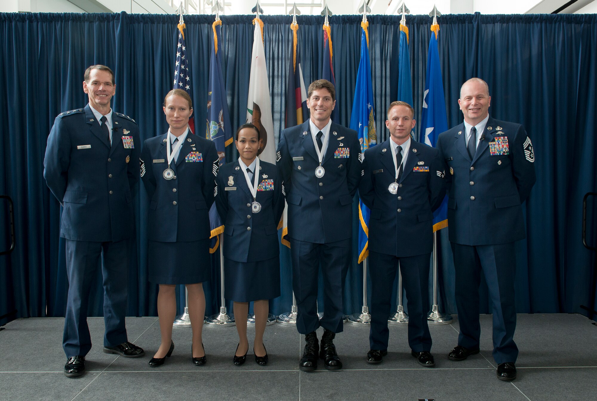 Lieutenant Gen. Stanley E. Clarke III, director of the ANG (left) and Chief Master Sgt. James W. Hotaling, command chief master sergeant of the ANG (far right), stand with the ANG outstanding Airmen of the Year during an All Call event Joint Base Andrews Md., Aug 6, 2015. The OAY winners are (left to right) Master Sgt. Sally J. Ford, Outstanding First Sergeant of the Year, Master Sergeant Maria Victoria R. Quitugua, Outstanding Senior NCO of the Year, Staff Sgt. Douglas P. Kechijian, Outstanding Non-Commissioned Officer of the Year and Senior Airman Jonathan R. Smail, Outstanding Airman of the Year. (Air National Guard photo by Master Sergeant Marvin. R. Preston, Released)