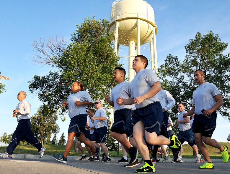 Airmen participate in a wing run on Grand Forks Air Force Base, N.D., Aug. 6, 2015. The two-mile long run was meant to promote fitness as well as unite Airmen from different squadrons of the base to form one cohesive team. (U.S. Air Force photo by Airman 1st Class Bonnie Grantham/Released)