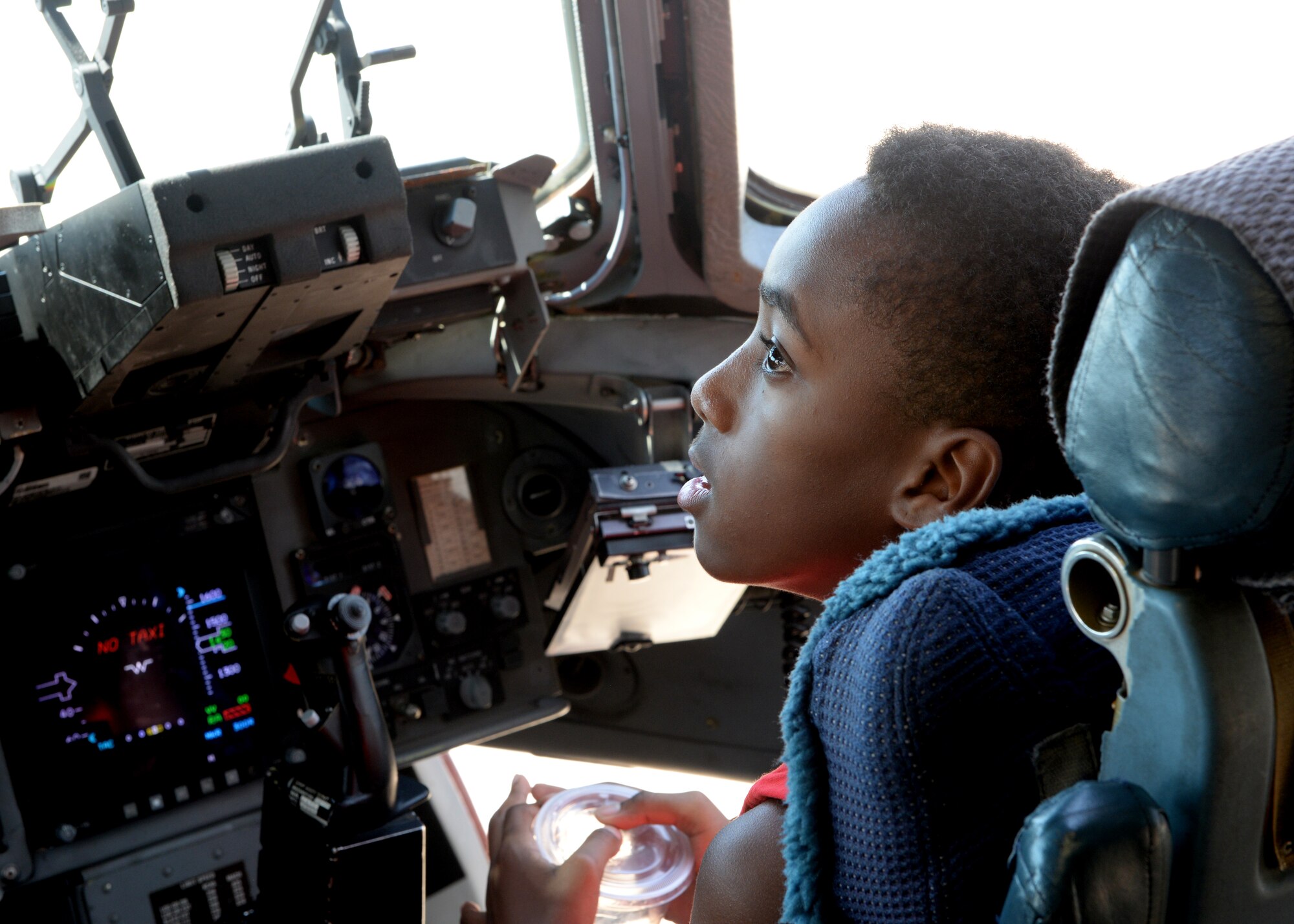 ALTUS AIR FORCE BASE, Okla. – A dependent child sits on the flight deck of a U.S. Air Force C-17 Globemaster III cargo aircraft during Operation Deploying Family, Aug. 5, 2015. During the event, participants toured a C-17, watched a military working dog demonstration, and were presented with giveaways that included canteens, binoculars, and dog tags. (U.S. Air Force photo by Airman 1st Class Megan E. Acs/Released) 
