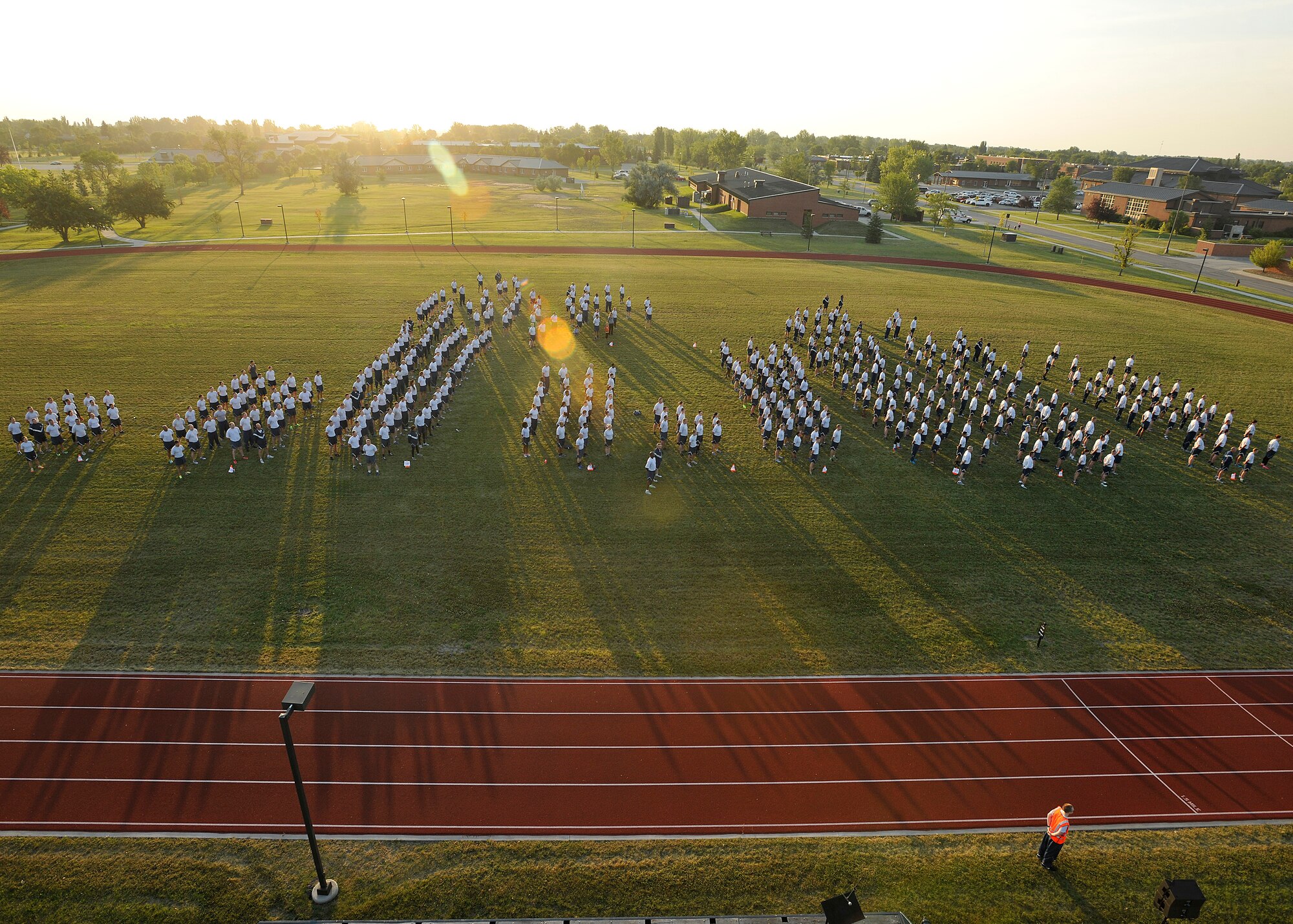 Airmen of the 319th Air Base Wing stand at parade rest during the playing of reveille during a wing run event on August 6, 2015, on Grand Forks Air Force Base, N.D. Squadrons from the 319th ABW gathered for a two-mile run to encourage physical fitness which is one of the four Comprehensive Airman Fitness Program pillars. (U.S. Air Force photo by Senior Airman Xavier Navarro/released)
