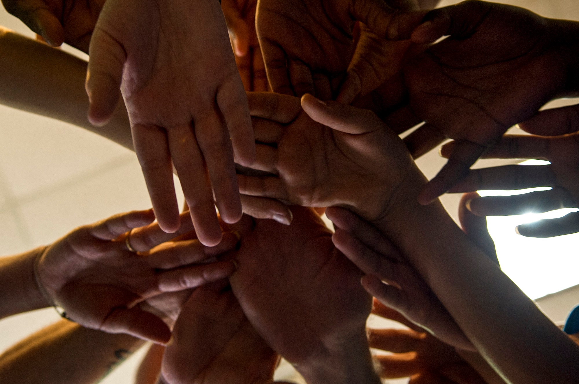 Make It Better 4 Teens students throw their hands together at the conclusion of a youth resilience camp, Aug. 7, 2015, at Seymour Johnson Air Force Base, North Carolina. The camp enforced teamwork throughout the week, which was designed to bring the children closer together. (U.S. Air Force photo/Airman Shawna L. Keyes)