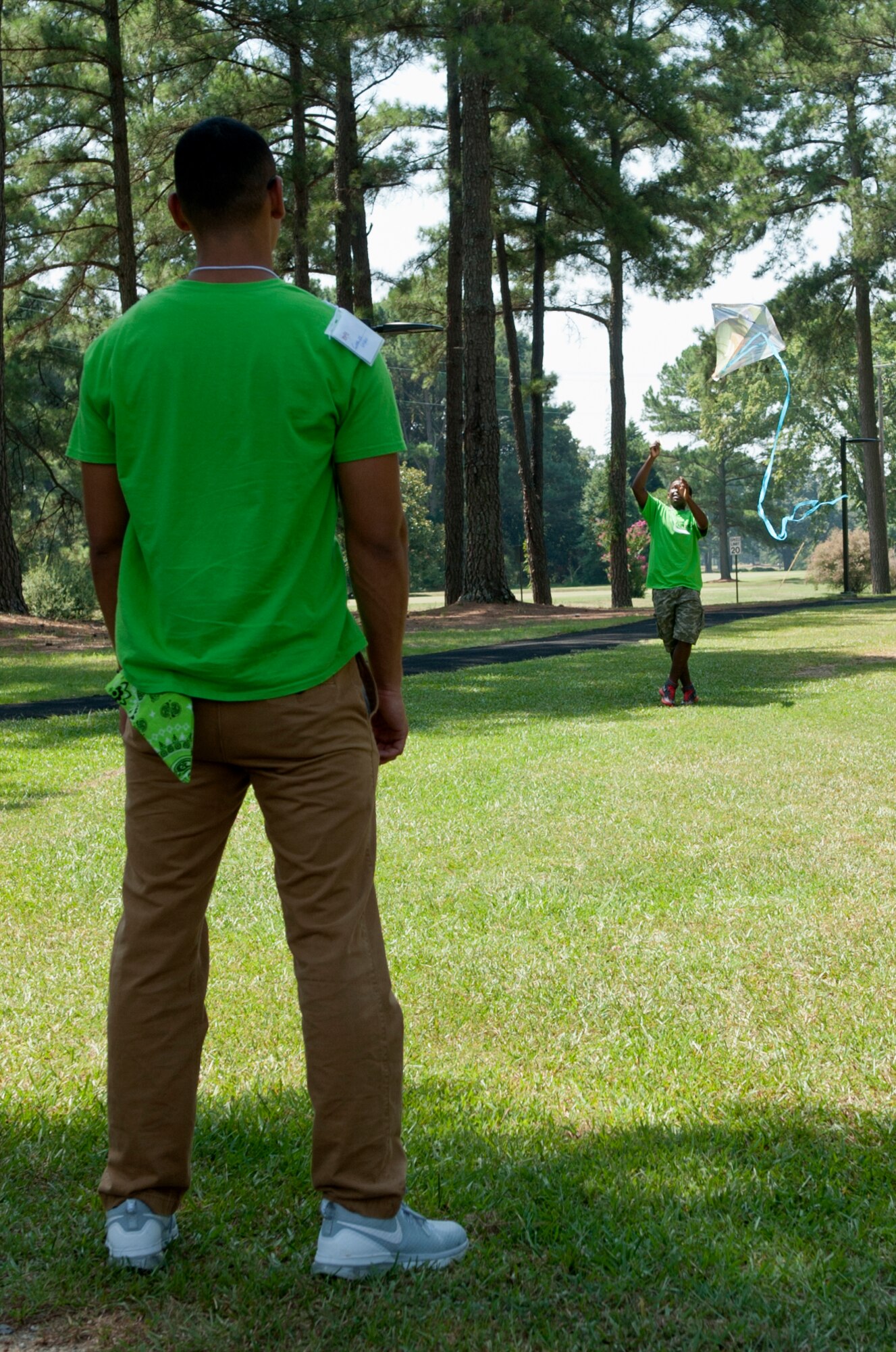 Senior Airman Charles Green, 4th Equipment Maintenance Squadron support technician, watches a Make It Better 4 Teens student fly a kite during a youth resilience camp, Aug. 6, 2015, at Seymour Johnson Air Force Base, North Carolina. Kite flying was a demonstration of spiritual resilience, showcasing how wind can be used to elevate an object. (U.S. Air Force photo/Airman Shawna L. Keyes)