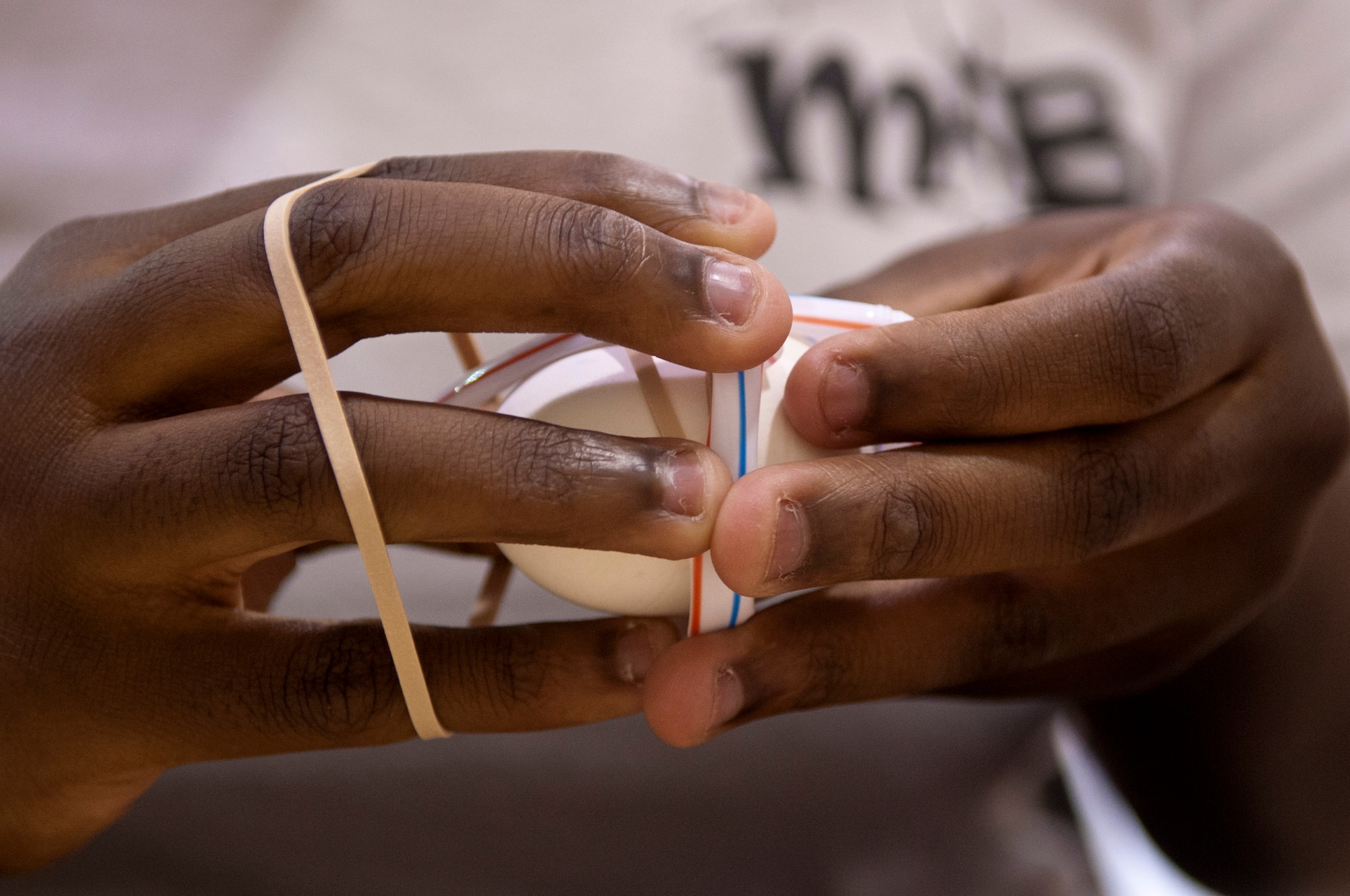 A Make It Better 4 Teens student wraps a rubber band around an egg during a youth resilience camp, Aug. 6, 2015, at Seymour Johnson Air Force Base, North Carolina. For this challenge, teams of two worked together to construct a housing unit capable of keeping an egg from breaking when dropped. (U.S. Air Force photo/Airman Shawna L. Keyes)