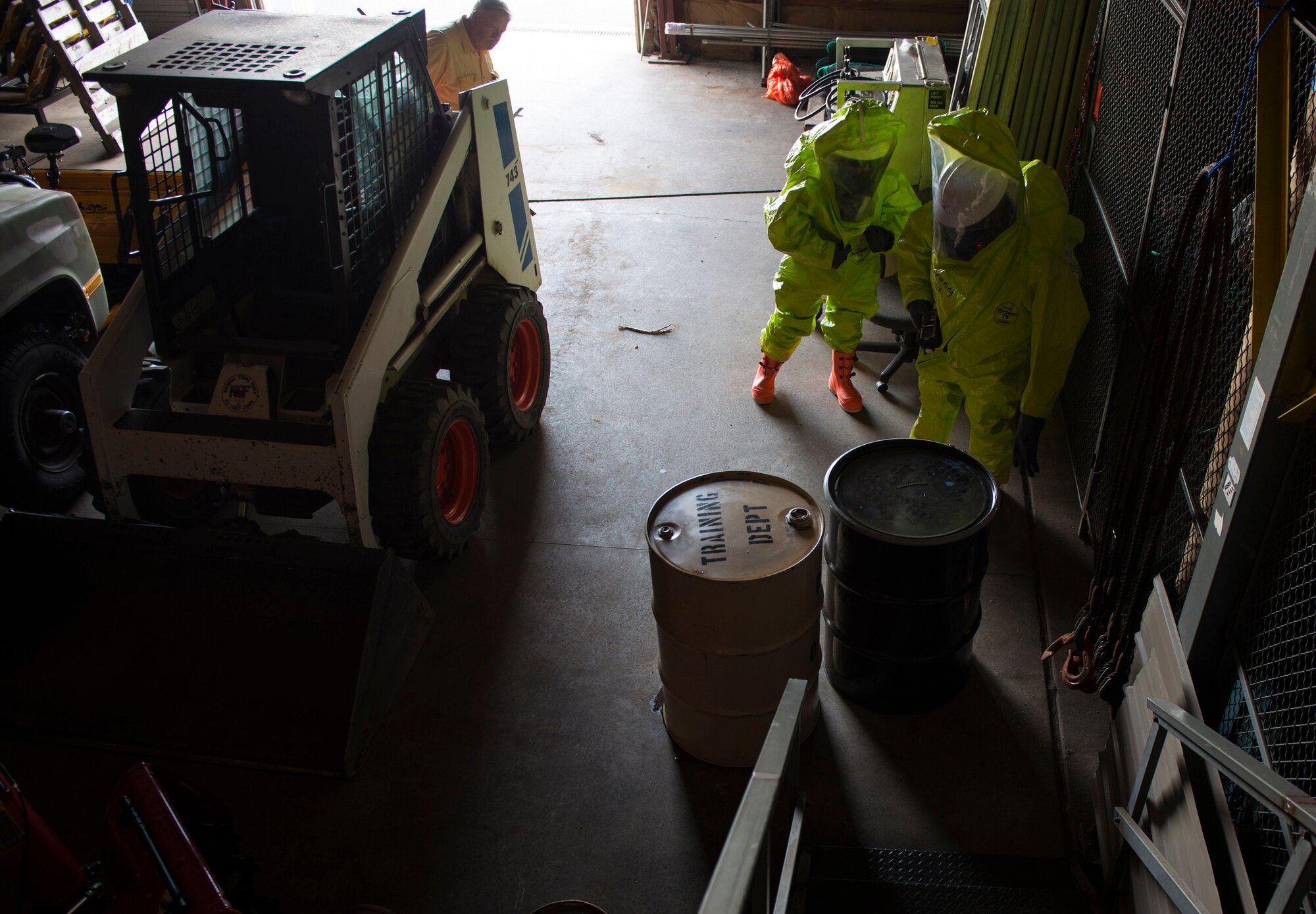 Two members of the U.S. Coast Guard Atlantic Strike Team take readings near oil drums in a simulated contaminated area during a hazardous materials scenario on Joint Base McGuire-Dix-Lakehurst, N.J., Aug. 6, 2015. The emergency scenario featured a hazardous material spill and AST needed to determine contents, mitigate the leak and recommend disposal options. (U.S. Air Force photo by Airman 1st Class Joshua King/Released)