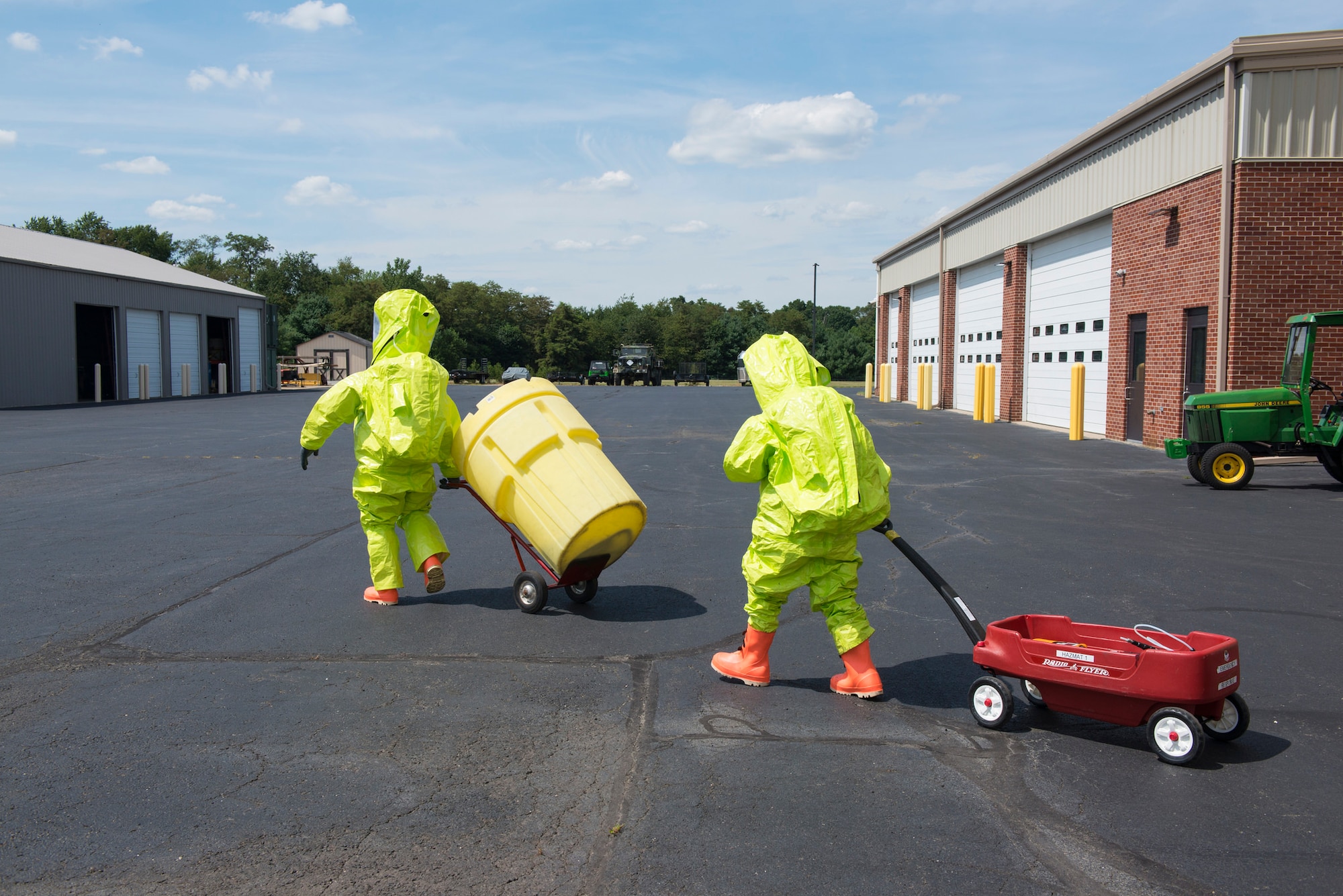 Two members of the U.S. Coast Guard Atlantic Strike Team walk toward a simulated contaminated area during a hazardous materials scenario on Joint Base McGuire-Dix-Lakehurst, N.J., Aug. 6, 2015. The AST provides disaster response along the East Coast from Maine to North Carolina. (U.S. Air Force photo by Airman 1st Class Joshua King/Released)