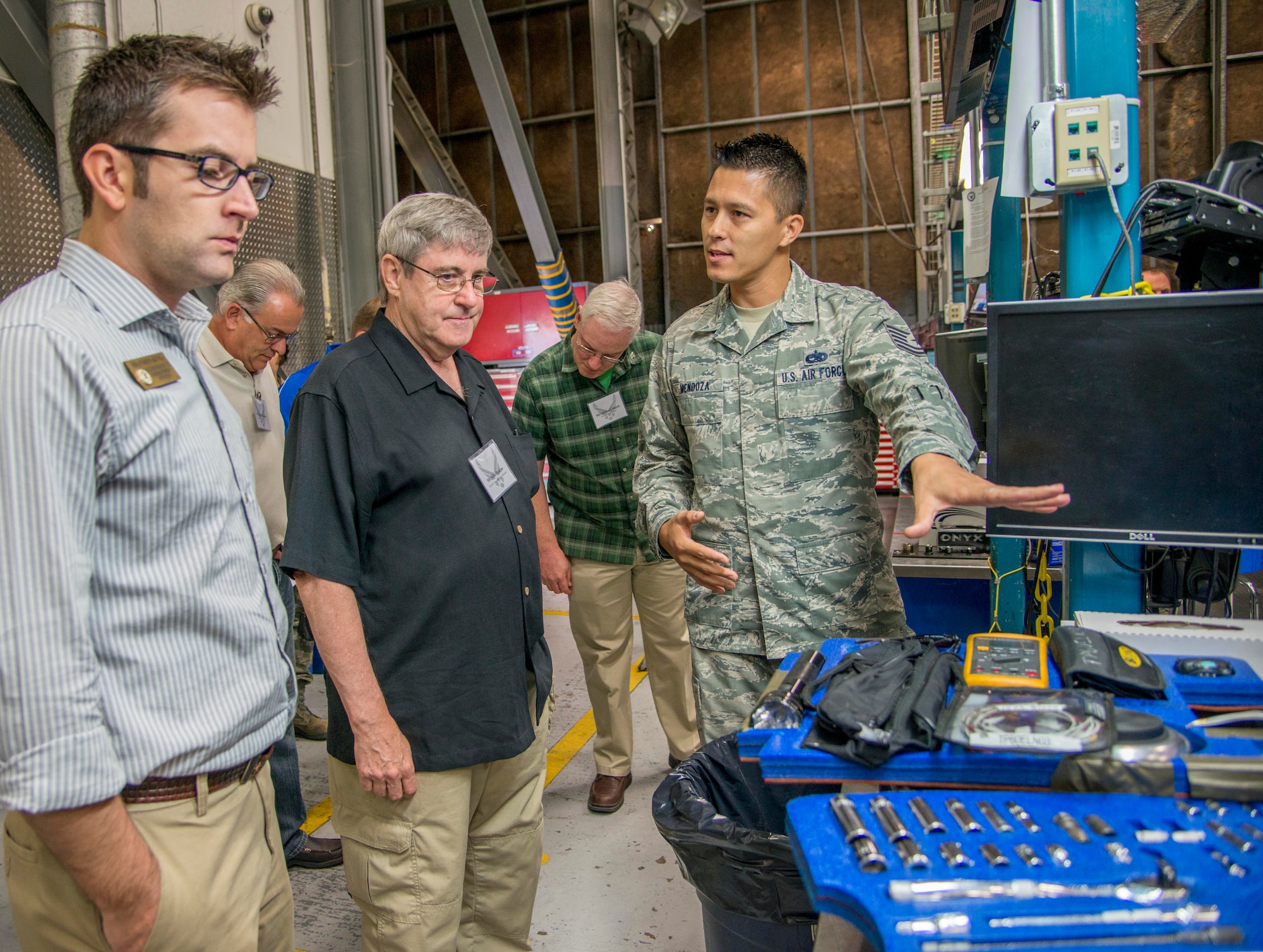 Tech Sgt. Stephen Mendoza, 60th Aircraft Maintenance Squadron crew chief, speaks with Brandon King, representative for Congressman Garamendi, and Mike Reagan, Travis Regional Armed Forces Committee executive board member, about the consolidated tool kit and the importance of tool control for their jobs during a tour of the 60th Maintenance Group July 31, 2015. Civic Leaders and honorary commanders were also briefed on safety, resource management and the hazardous material program while visiting the 60th AMXS. (U.S. Air Force photo/Senior Airman Nicole Leidholm)