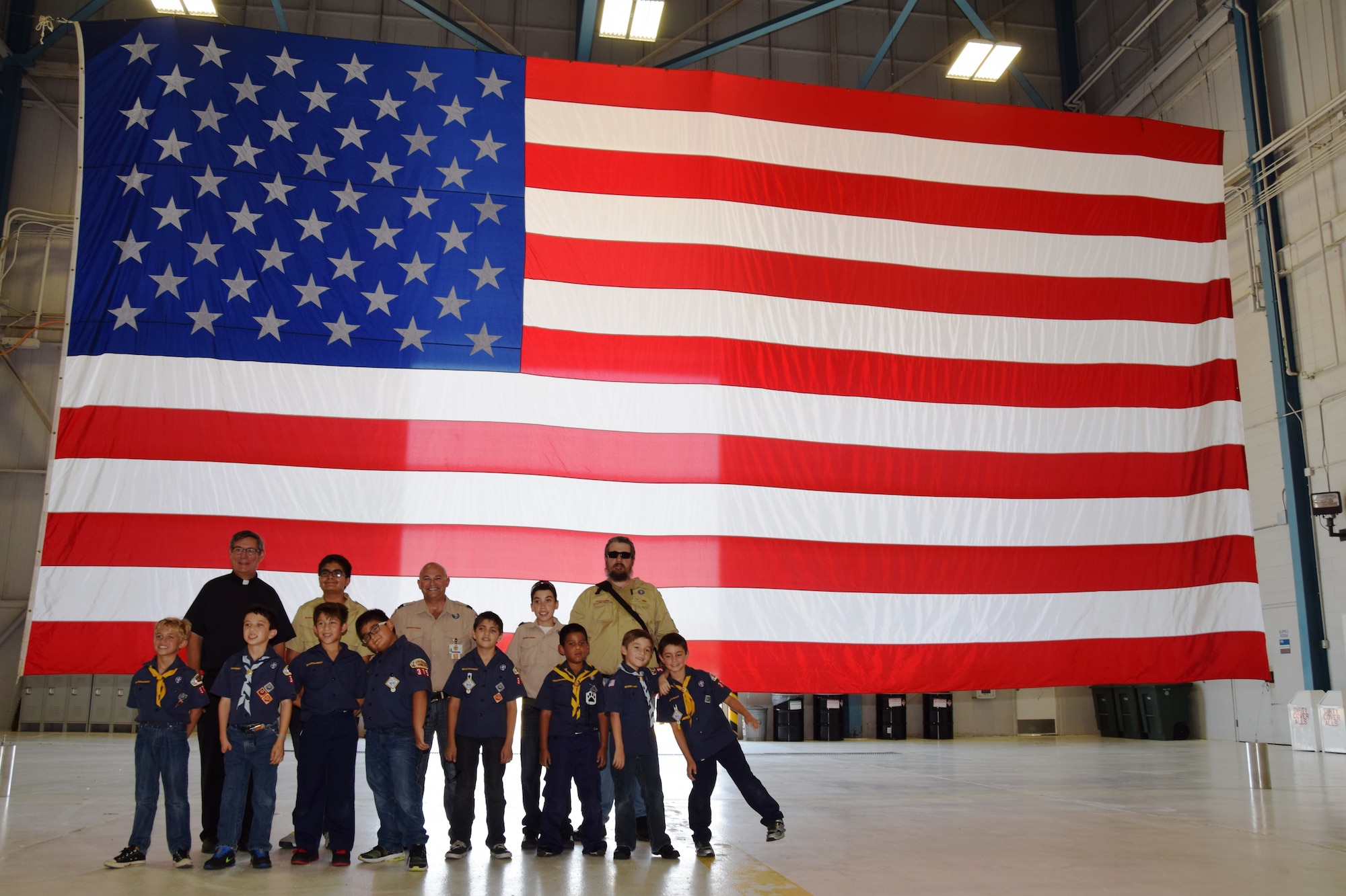 During their field trip at Joint Base San Antonio-Lackland, Texas on Aug. 6, 2015, Boy Scout Troop 375 posed for a photo at the wing’s wash rack hanger prior to reciting the Pledge of Allegiance and saluting the United States flag. The Scouts, from St. Gregory the Great Catholic Church, also toured the C-5A Galaxy and listened to Tech. Sgt. Jesse Sanchez, a 68th Airlift Squadron loadmaster explain the capabilities of the aircraft. (U.S. Air Force photo/Tech. Sgt. Carlos J. Trevino)