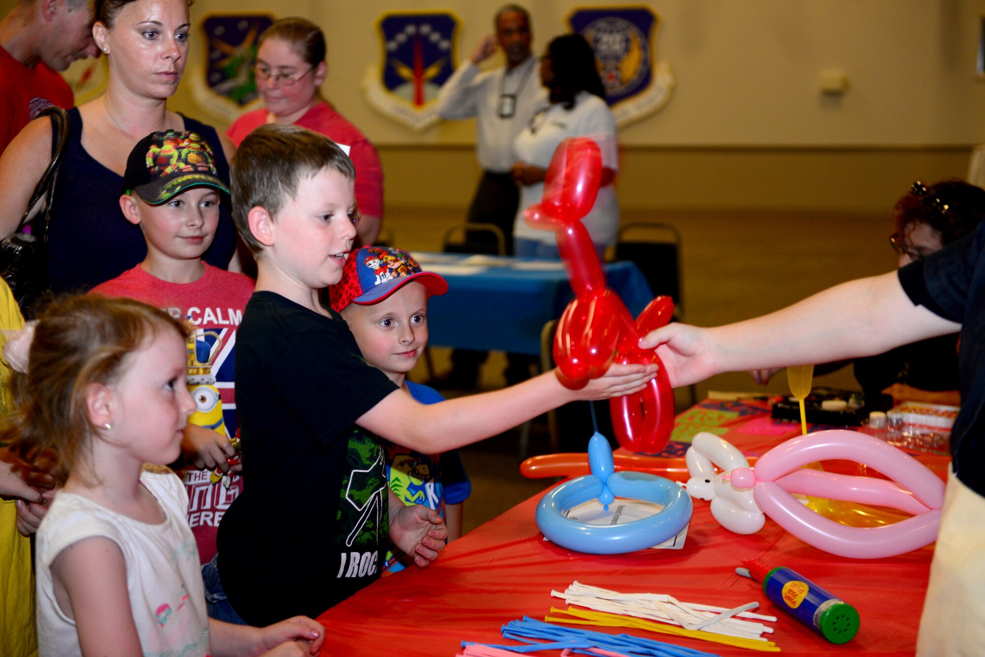 Kids receive balloon animals during National Night Out at Barksdale Air Force Base, La., Aug. 4, 2015. Children enjoyed balloons, burgers, inflatable slides and got to see firetrucks, Humvees and police cars during the festivities. (U.S. Air Force photo/Airman 1st Class Luke Hill)