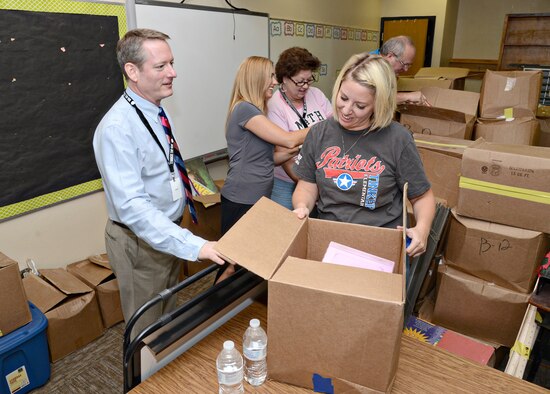 From left, Dr. Rick Cobb, superintendent of Mid-Del School District, and Wendy Eaton, Tinker Elementary principal, check out all of the furniture and supplies to be reorganized with first grade teacher, Carole Peery, and school counselor, Dawn Hartman. Teachers, staff and volunteers showed up to Tinker Elementary on Aug. 3 to help with a massive moving-in day. (Air Force photo by Kelly White/ReleasedBack to School)