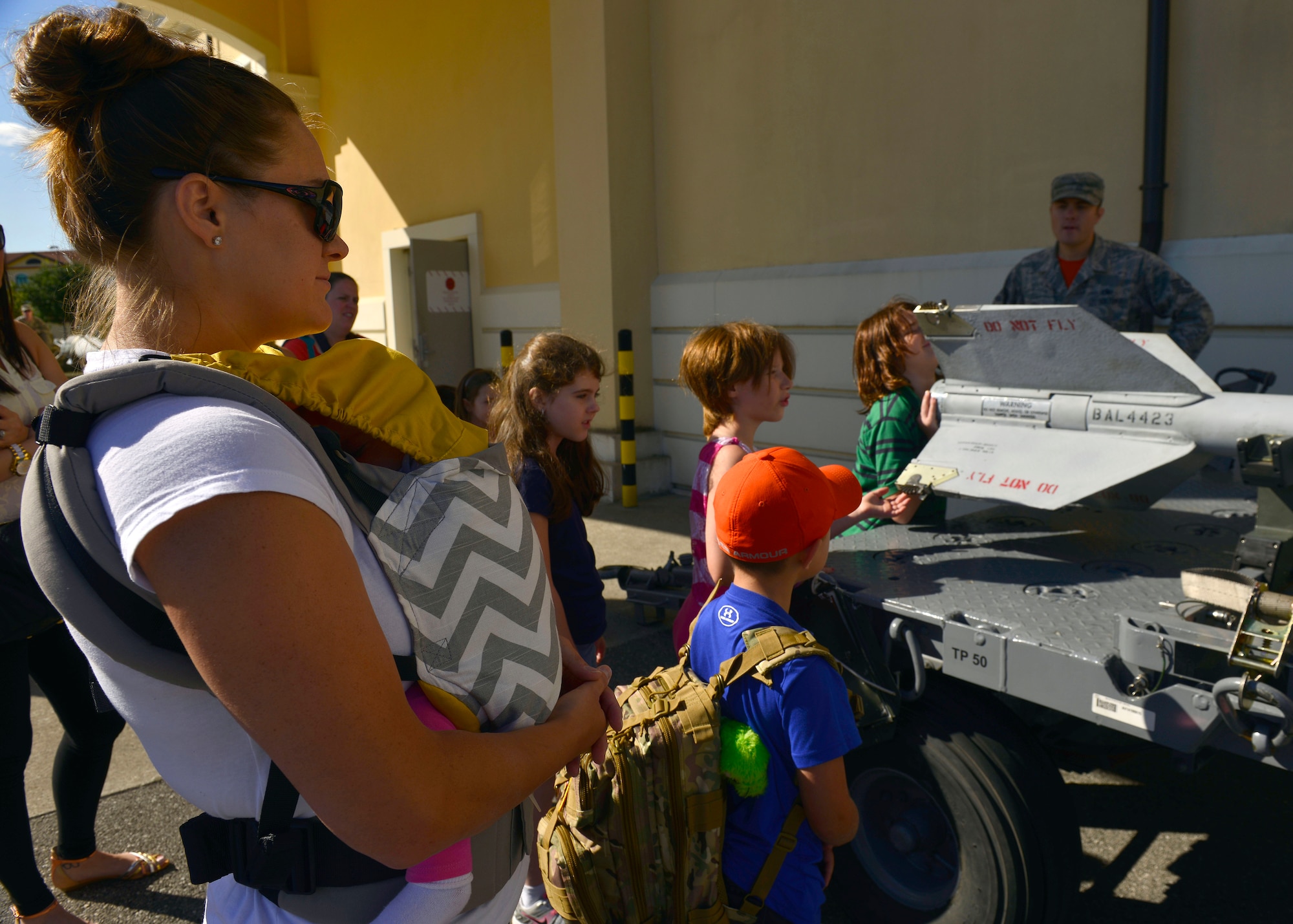 Anna Bledsoe, wife of U.S. Air Force Staff Sgt. Troy Bledsoe, and her son look at munitions equipment during the 31st Munitions Squadron family day, July 31, 2015, at Aviano Air Base, Italy. The event provided families an orientation of work accomplished at the squadron. (U.S. Air Force photo by Airman 1st Class Cary Smith/Released)
